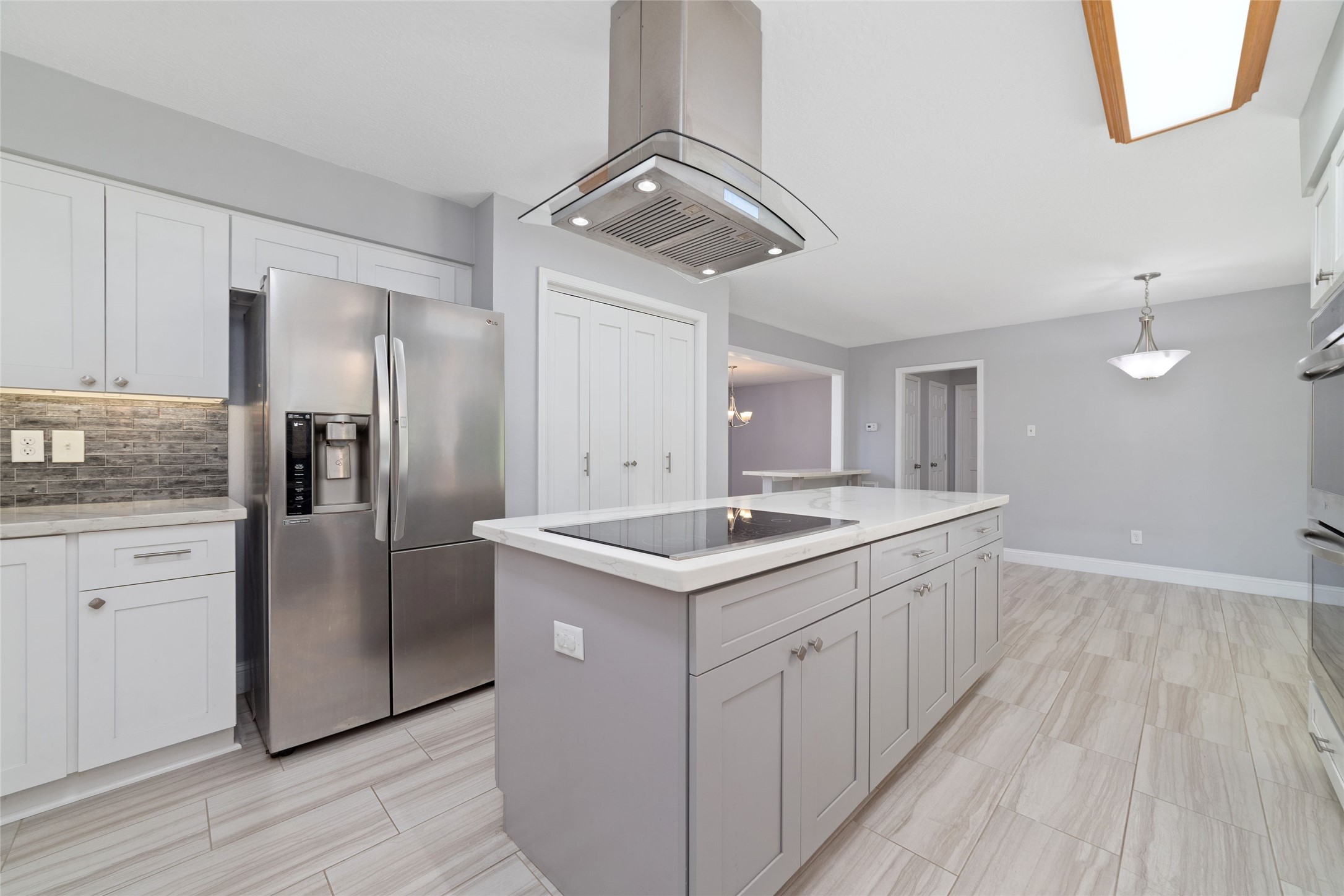 Designed for both cooking and connection! The oversized island features an electric cooktop with a contemporary stainless steel vent hood, while the thoughtfully arranged refrigerator, pantry, and generous cabinetry keep everyday essentials within easy reach. Just beyond, the spacious Breakfast Room offers a welcoming place to gather for casual meals and everyday moments.