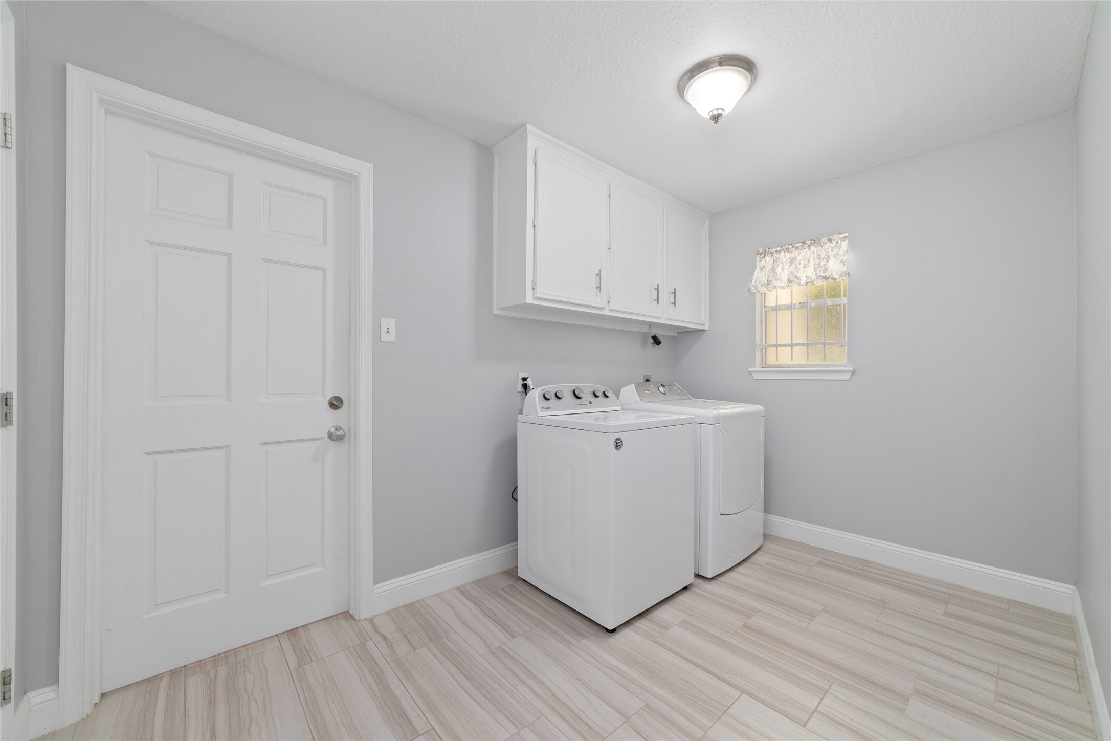 Everyday convenience meets smart storage! Located just off the Kitchen and Breakfast Room, this spacious Laundry Room features overhead cabinetry and two additional storage closetsperfect for household essentials, pantry overflow, or keeping those seldom-used kitchen appliances neatly tucked away.