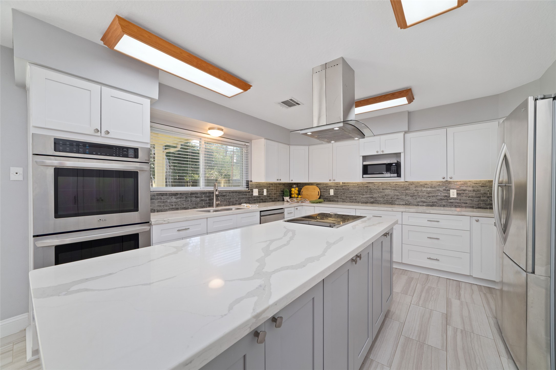 Beautifully remodeled with today's lifestyle in mind! This bright, inviting Kitchen features an oversized island with gorgeous quartz countertops, updated cabinetry, stainless steel appliances, and abundant workspace. Whether preparing everyday meals or hosting friends and family, this is a space designed to bring everyone together.