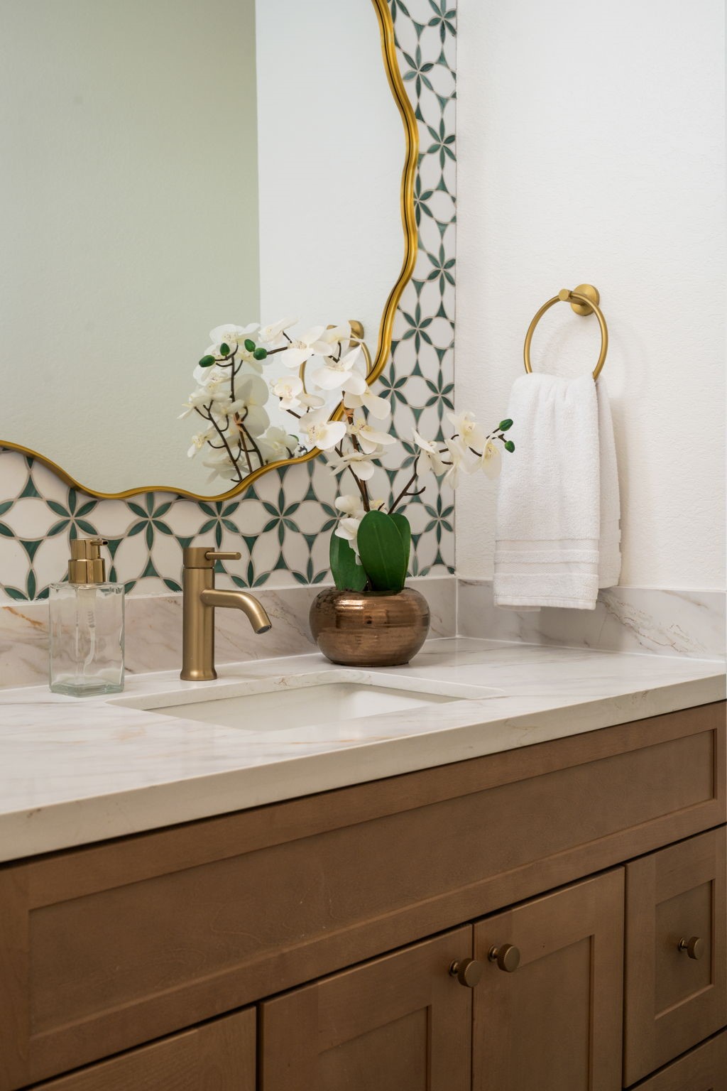 The powder bath features updated vanity cabinetry, contemporary fixtures, and designer lighting details. Renovated finishes continue throughout the space with a clean and modern presentation. Positioned near the main entertaining areas for guest convenience.