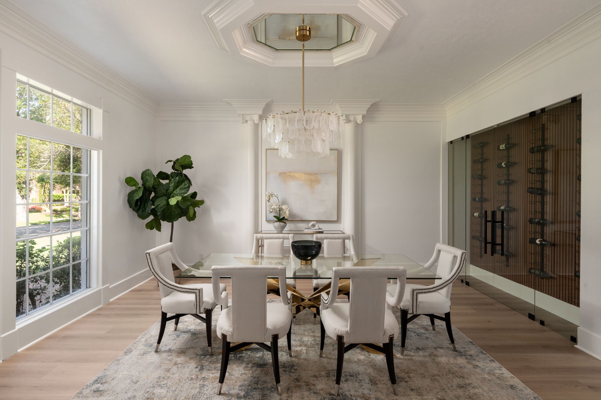The formal dining room was designed for entertaining with updated lighting, detailed millwork, and generous proportions for larger gatherings. Oversized windows overlook the front landscaping while bringing additional depth to the room. The space transitions naturally into the foyer and adjacent living areas.