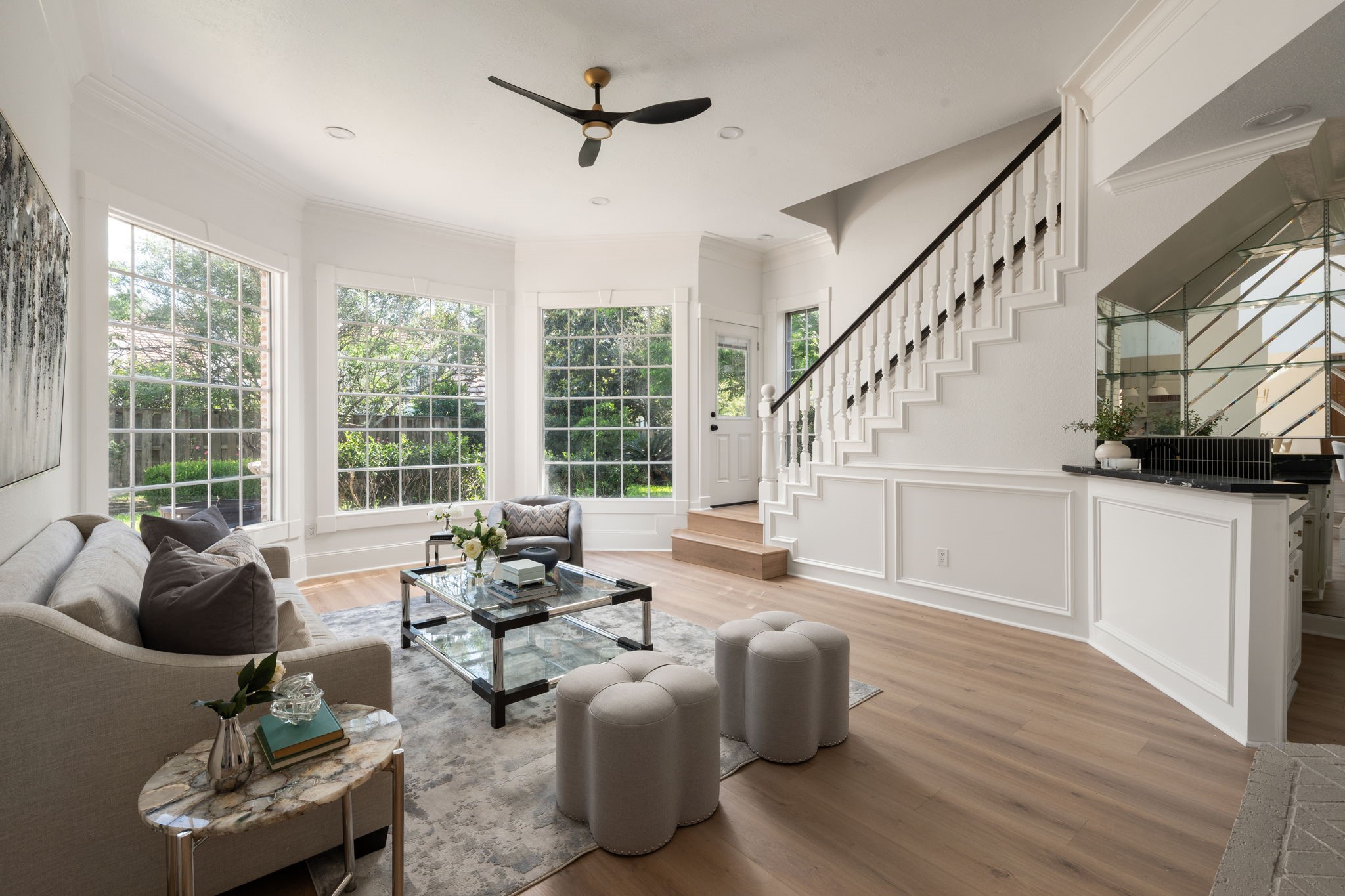 The den provides an additional gathering space overlooking the staircase and surrounding entertaining areas. Large windows, updated flooring, and clean-lined finishes continue throughout the room. Its open layout allows flexibility for casual living, media use, or lounge seating.