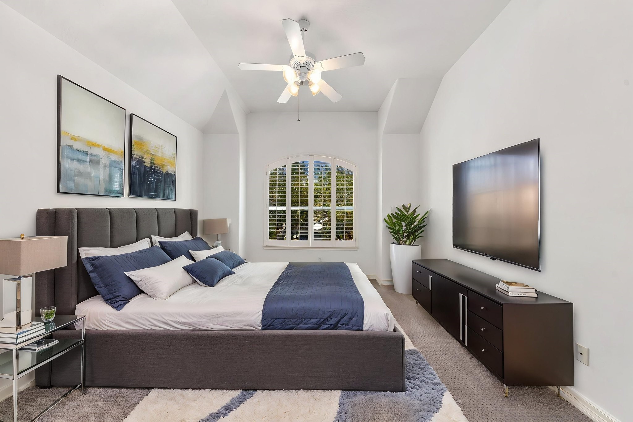 The largest of the three secondary bedrooms features a vaulted ceiling, arched window with plantation shutters & ceiling fan, offering plenty of flexibility for a variety of uses.  Virtually staged to illustrate furniture placement.
