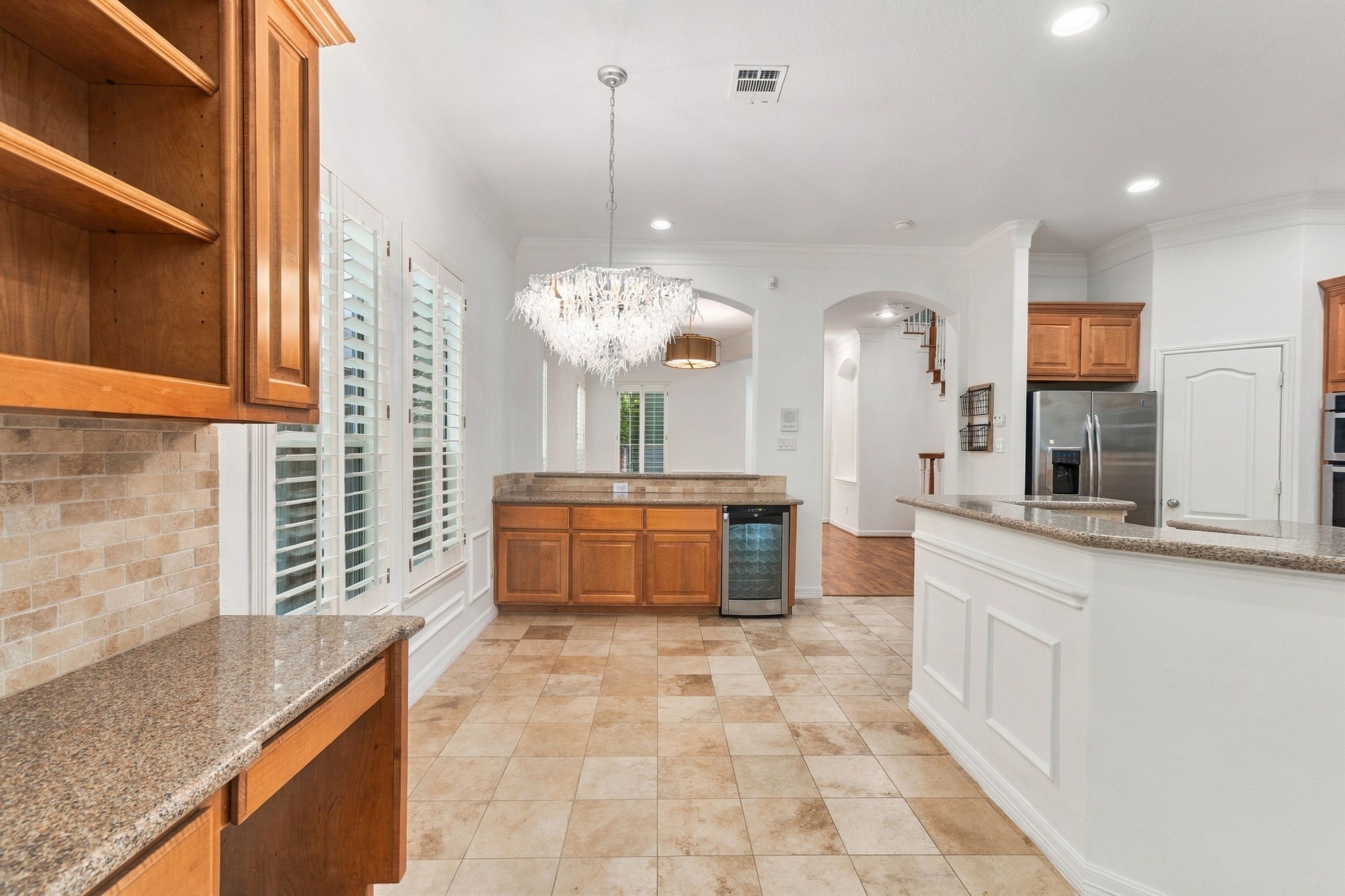 An open connection between the formal dining room, breakfast area & kitchen creates an easy flow for entertaining. A dedicated butler's bar with built-in wine fridge, additional cabinetry & a convenient built-in desk adds both style and functionality.