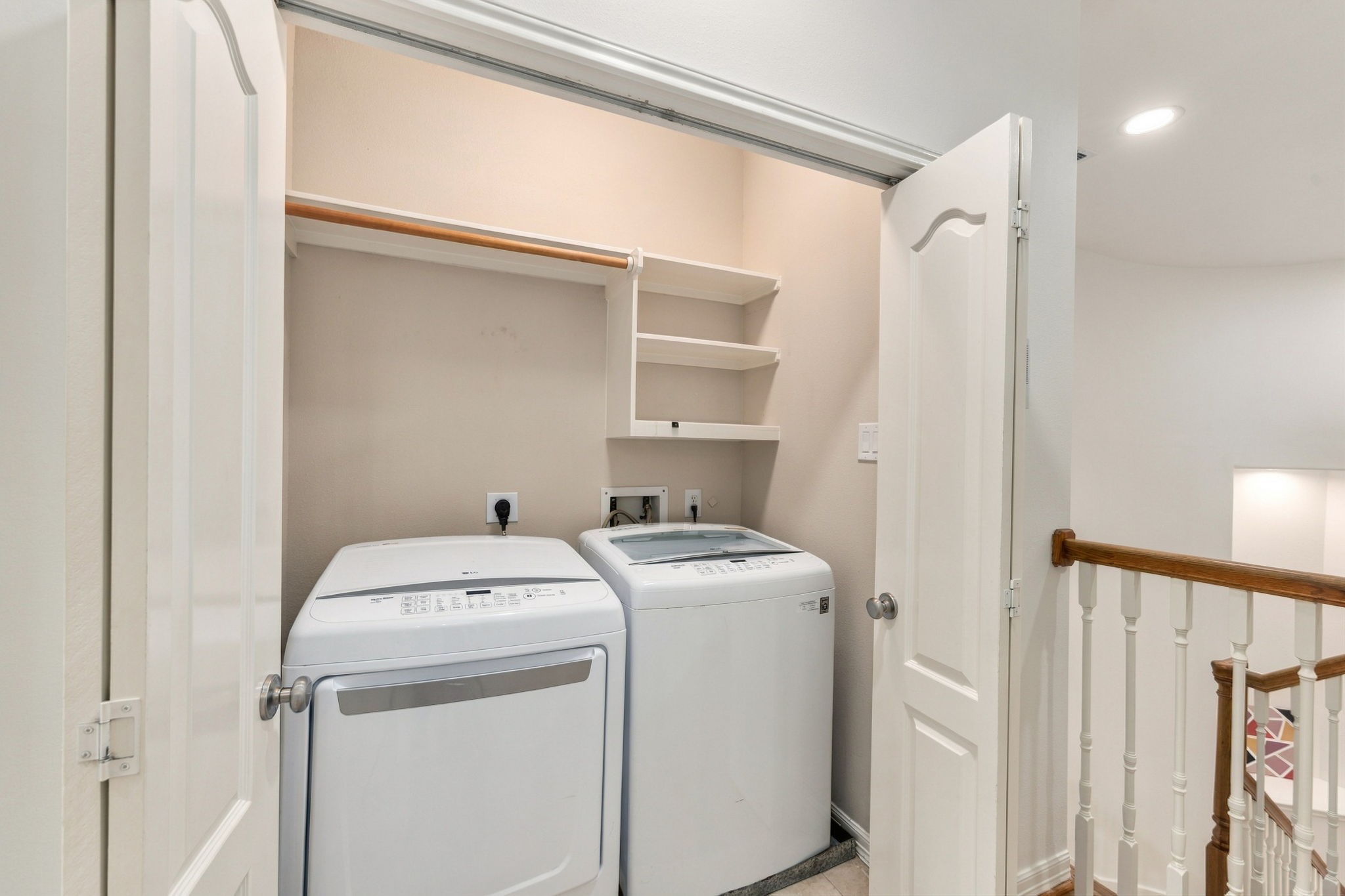 Conveniently located upstairs near all four bedrooms, the laundry area includes built-in shelving for additional storage.