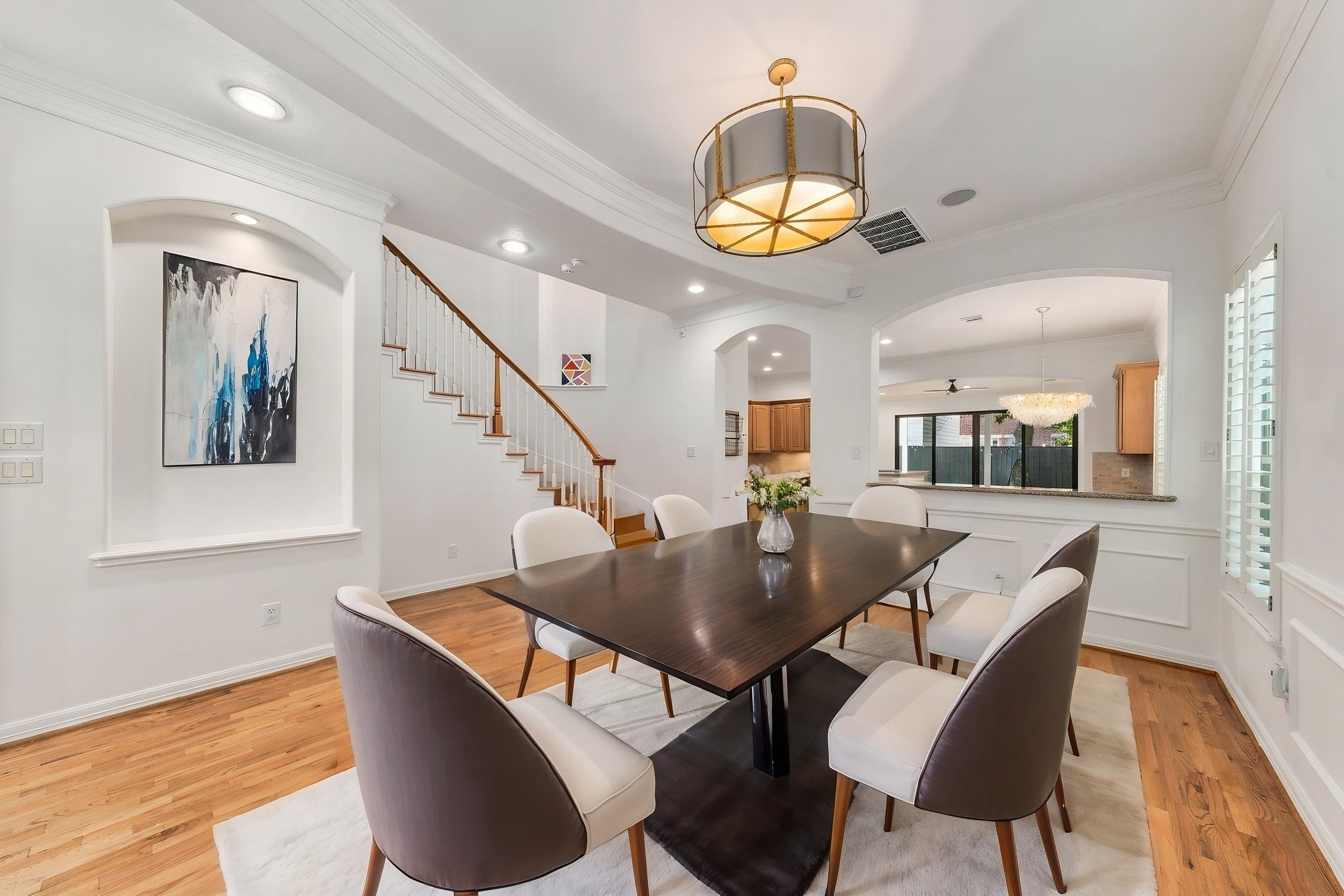 The formal dining room features beautiful hardwood floors, classic millwork, plantation shutters & a striking designer light fixture. An elegant setting for both everyday dining & entertaining. Virtually staged.