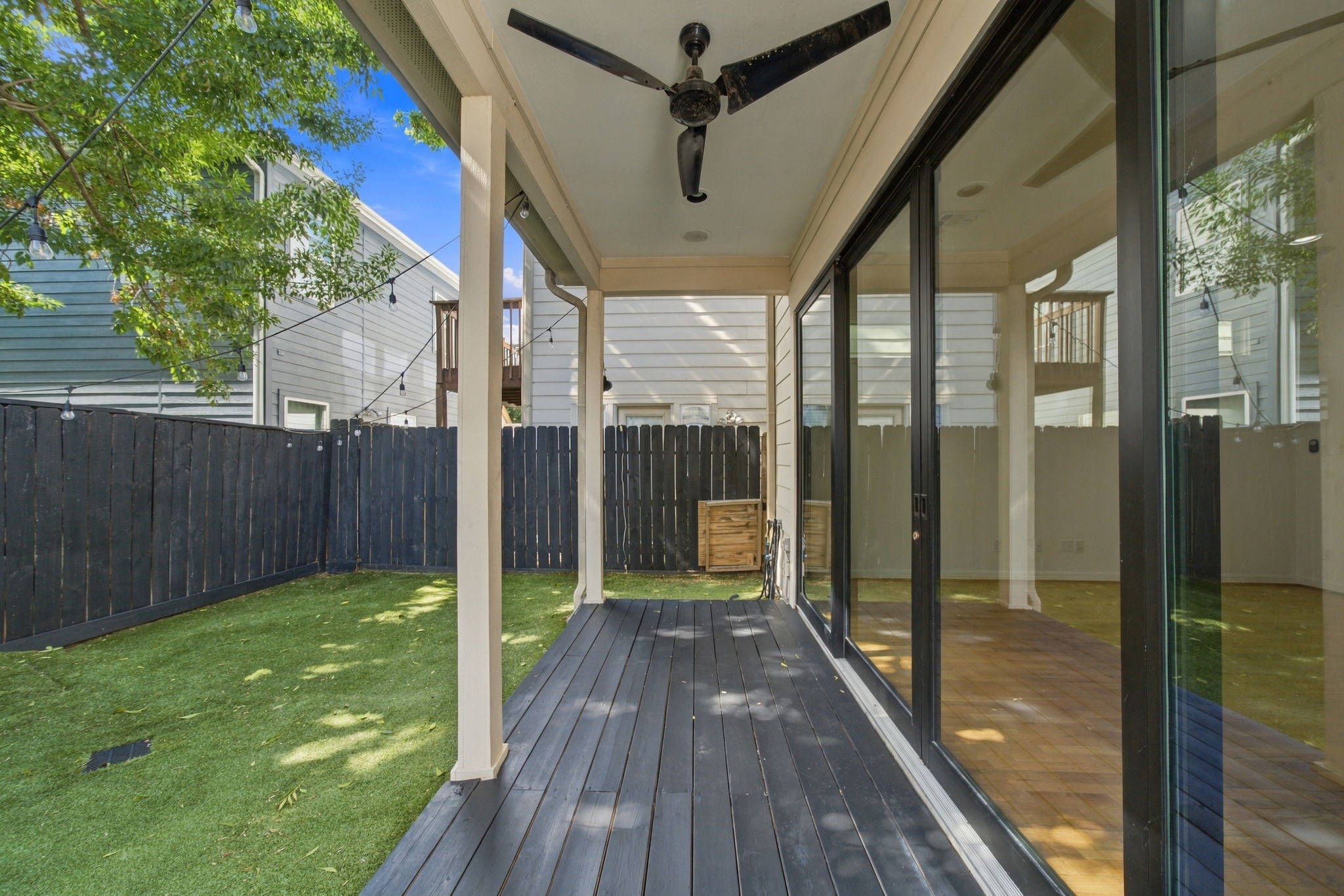 Enjoy easy indoor-outdoor living with recently installed sliding glass doors opening to a covered patio with ceiling fan, string lighting & low-maintenance turf backyard. A wonderful space for relaxing or entertaining.