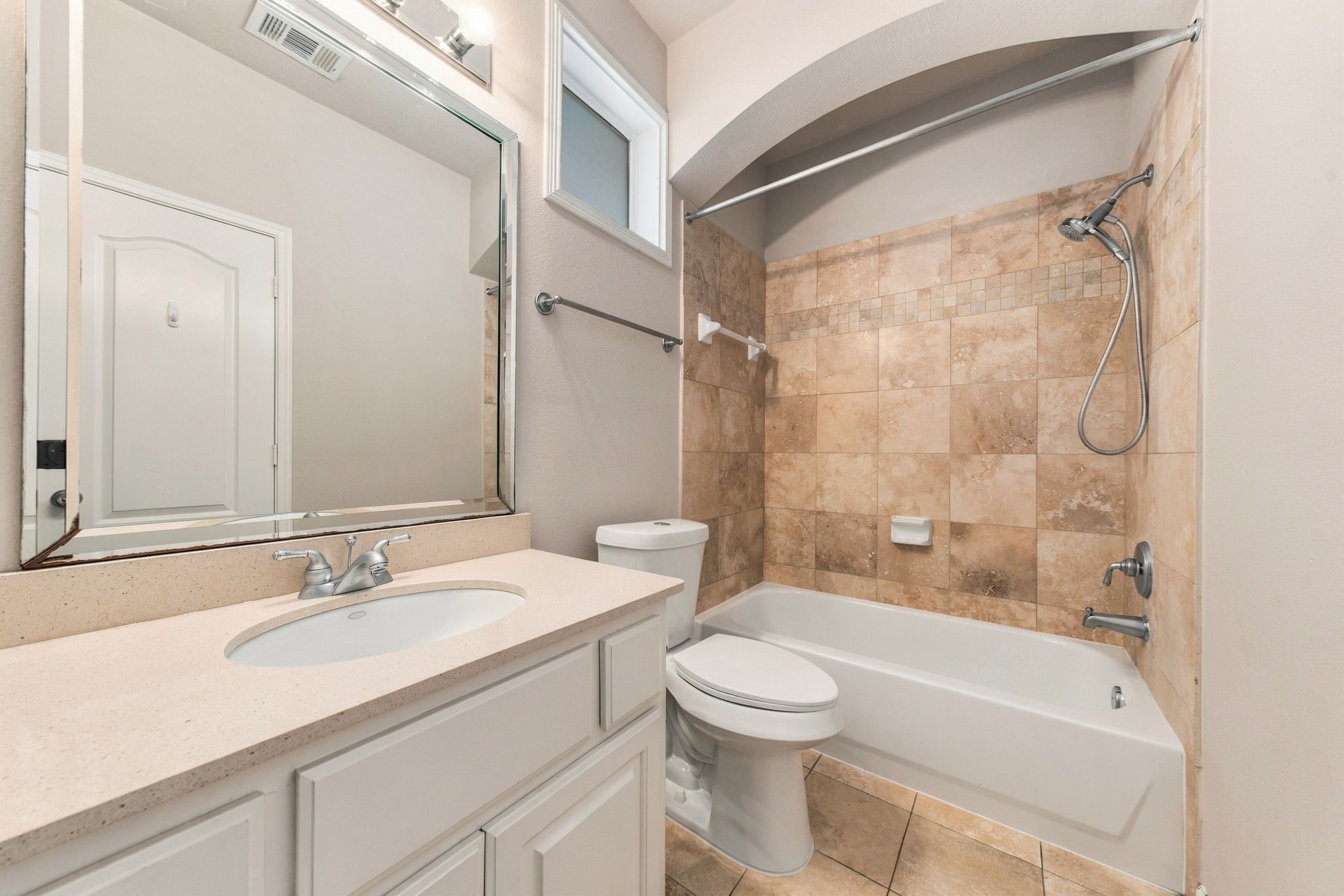 Upstairs secondary bathroom features a tub/shower combination with tile surround, spacious vanity & neutral finishes.