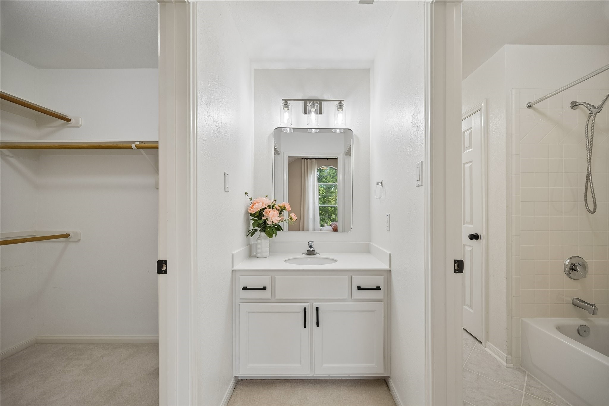This bathroom includes a spacious vanity area with direct access to a walk-in closet and the bathing area. A well-designed layout provides both comfort and everyday convenience.