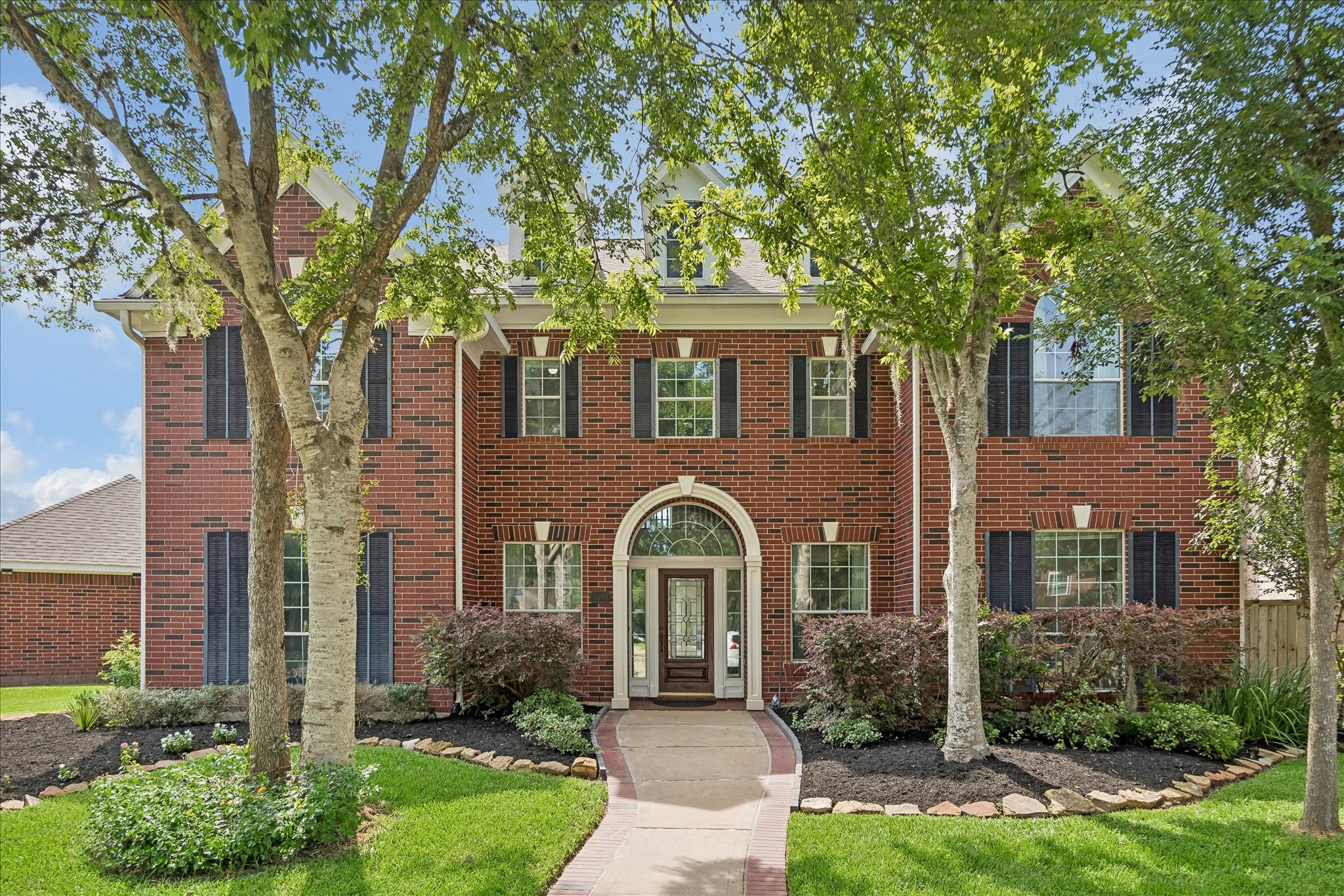 A stately traditional brick exterior on a corner cul-de-sac lot ,elegant arched entry, and mature shade trees create a warm and impressive first impression. Meticulously maintained landscaping enhances the home's classic curb appeal.