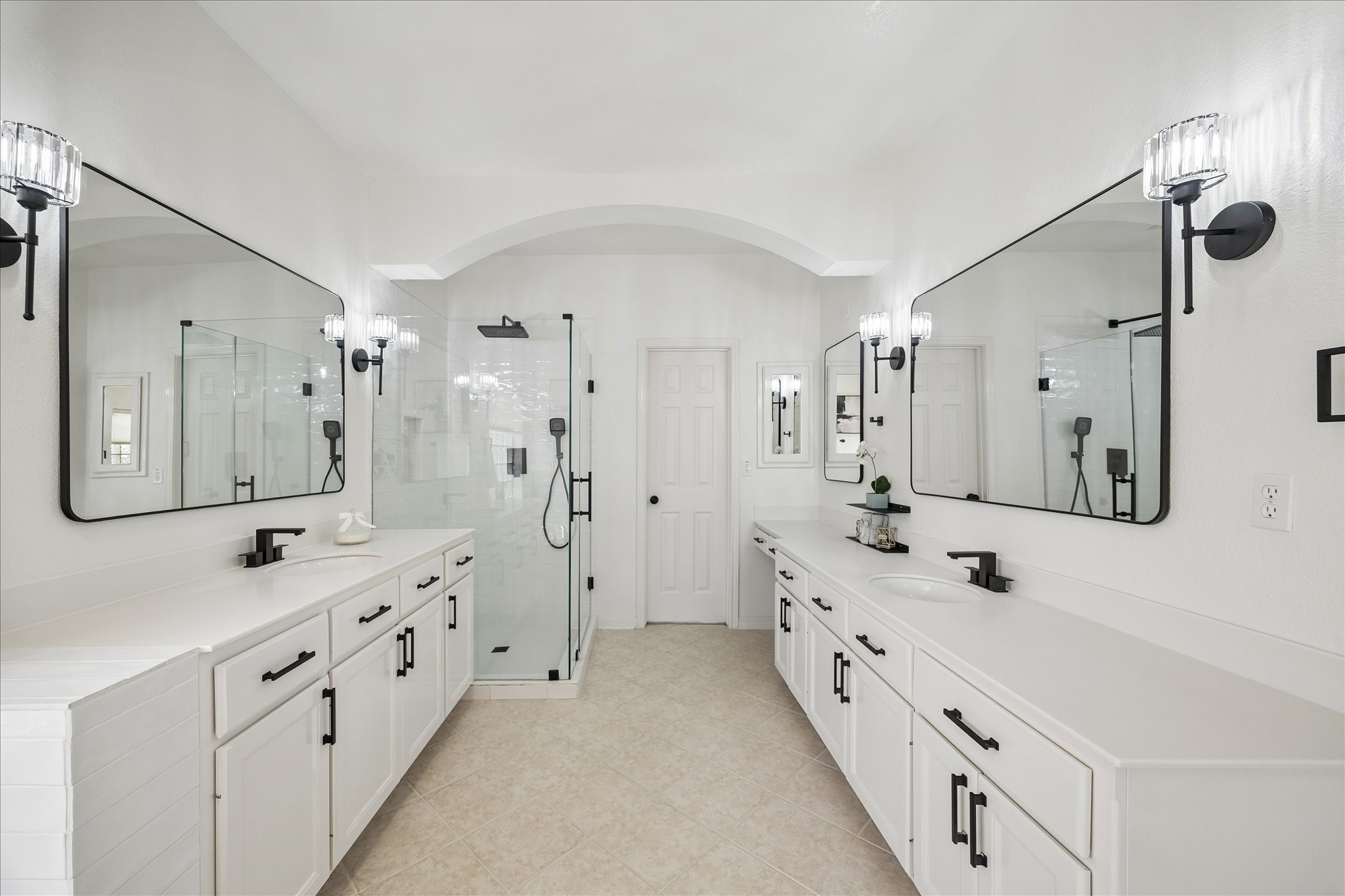 This remodeled spa-inspired bath features dual vanities, framed mirrors, and a stunning walk-in glass shower with designer finishes. A bright, open layout creates a luxurious everyday experience. This remodeled spa-inspired bath features dual vanities, framed mirrors, and a stunning walk-in glass shower with designer finishes. A bright, open layout creates a luxurious everyday experience.
