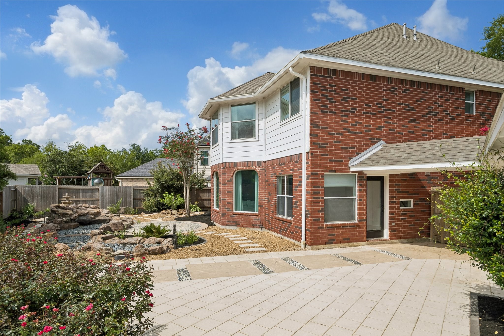 The spacious patio offers plenty of room for outdoor dining, relaxing, or entertaining while overlooking the beautifully designed backyard. Thoughtfully planned landscaping creates a peaceful outdoor retreat.