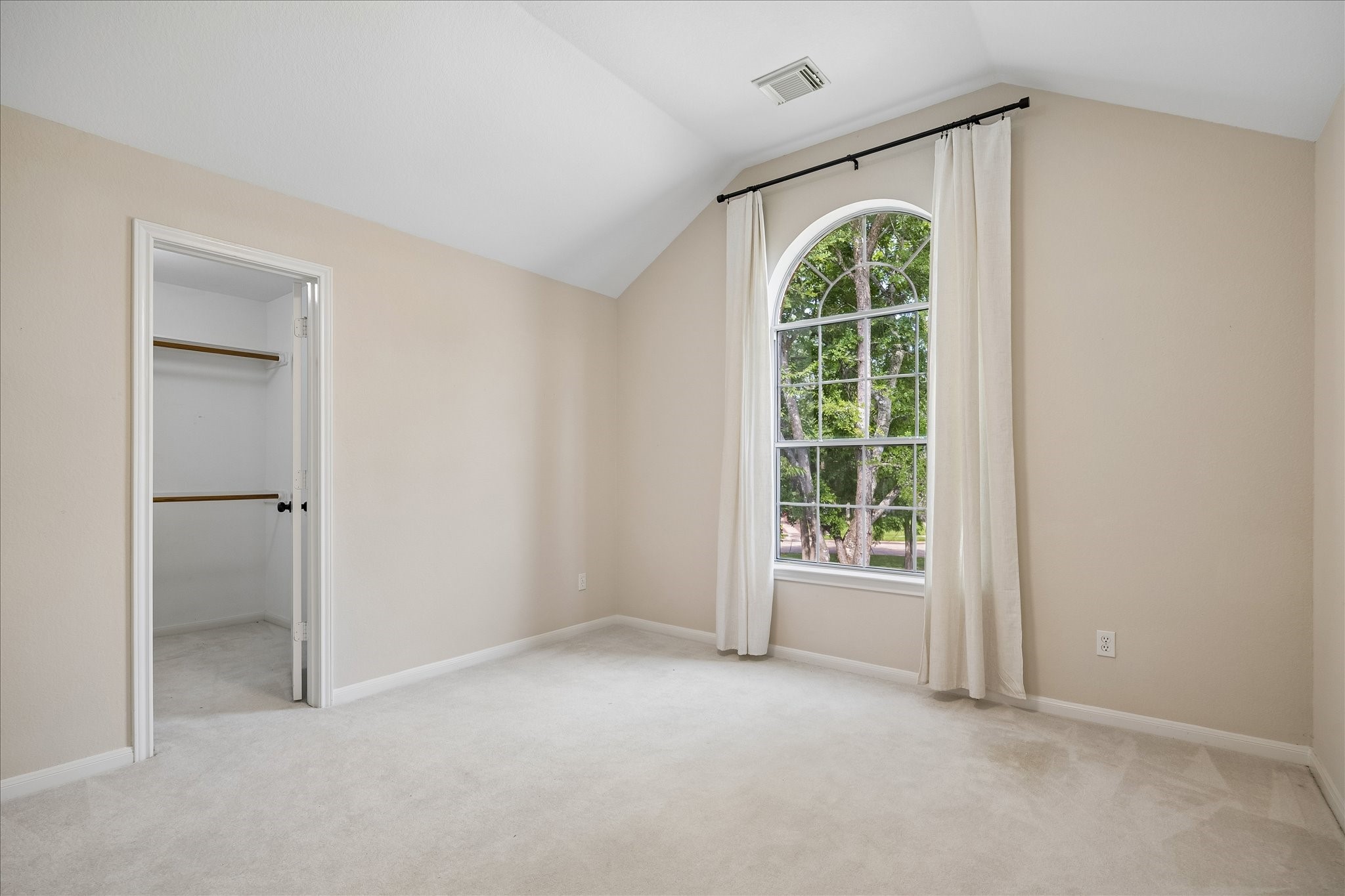 Another secondary bedroom #5 showcases a charming arched window and convenient walk-in closet, offering both comfort and functionality for family or visitors.