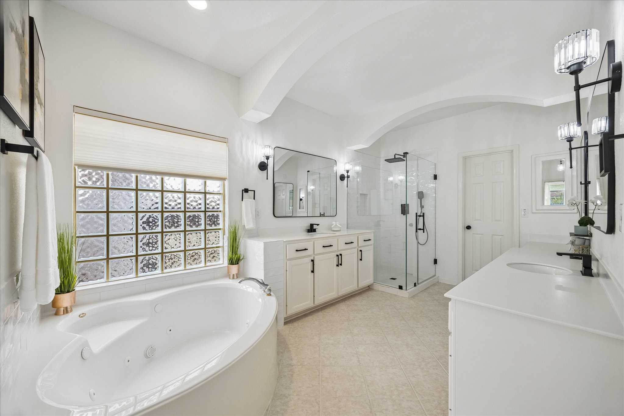 Relax and recharge in the soaking tub, perfectly complemented by the beautifully updated shower and expansive dual-sink vanity. Elegant lighting and modern fixtures elevate every detail.