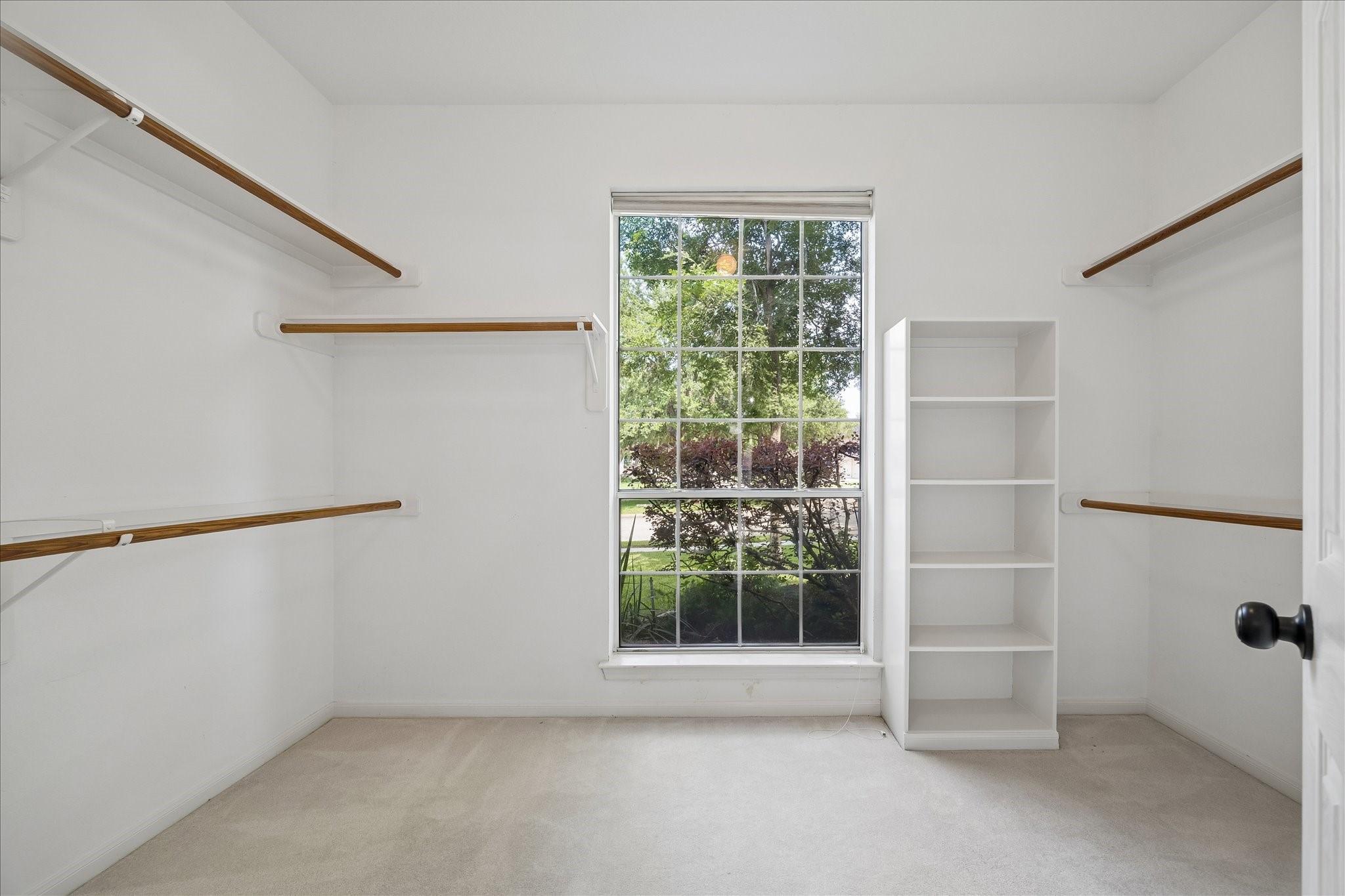 This is one of two walk-in closets and offers abundant hanging space, built-in shelving, and a window that fills the room with natural light. Designed for easy organization, there's plenty of room for every wardrobe.