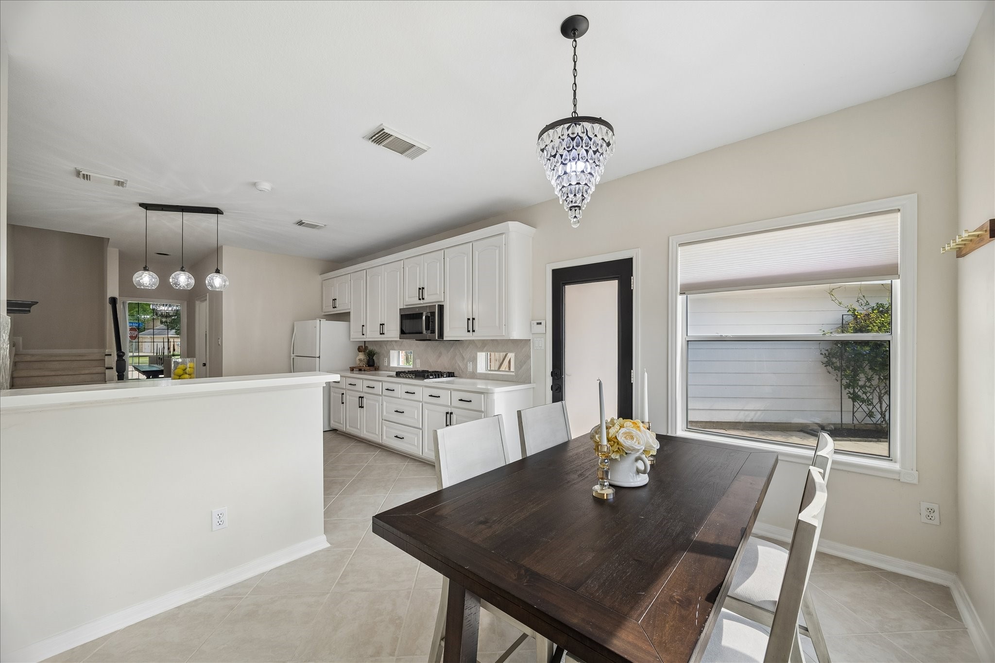 The sunny breakfast area provides a comfortable spot for casual meals while connecting effortlessly to the kitchen. Large windows and backyard access keep the space bright and inviting throughout the day.