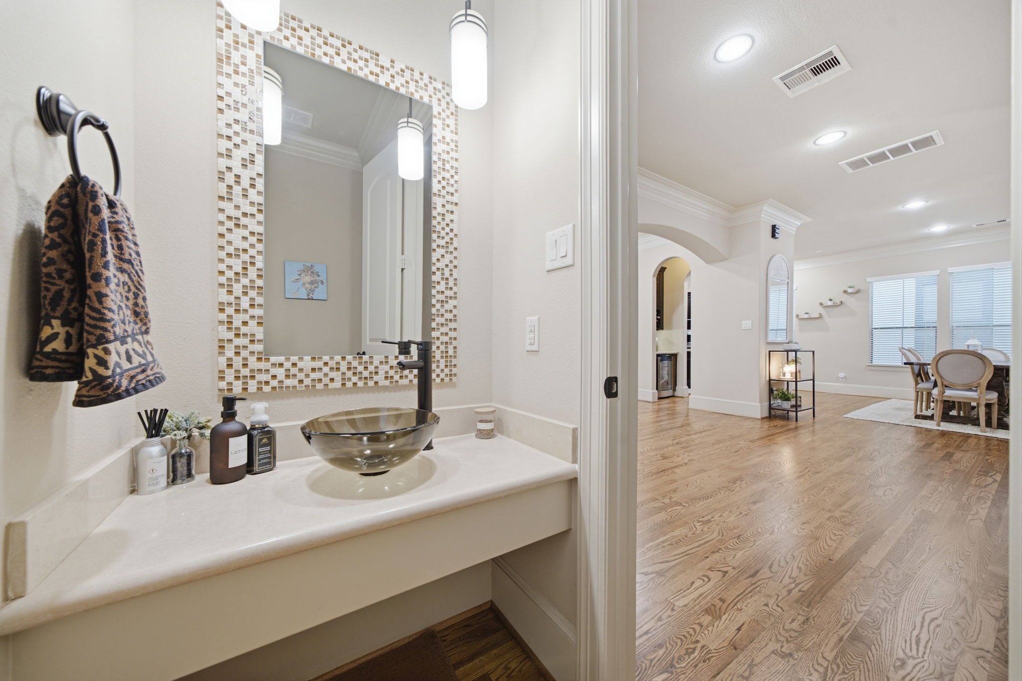Powder room located on the living room level with marble countertop and designer vessel sink.