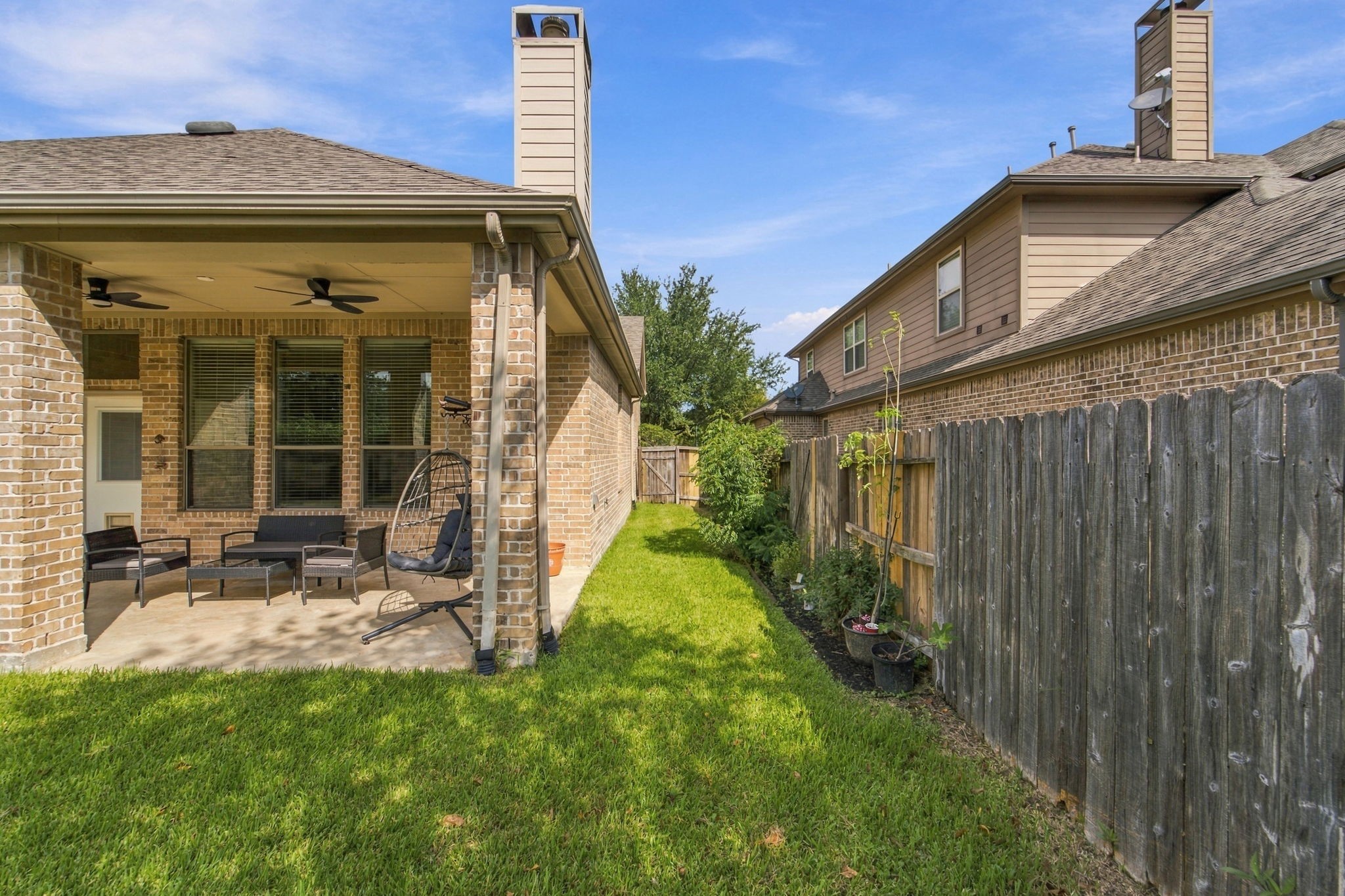 A fenced side yard with a gate makes it easy to move between the front and backyard. Its a practical layout for pets, play, or a little gardening.