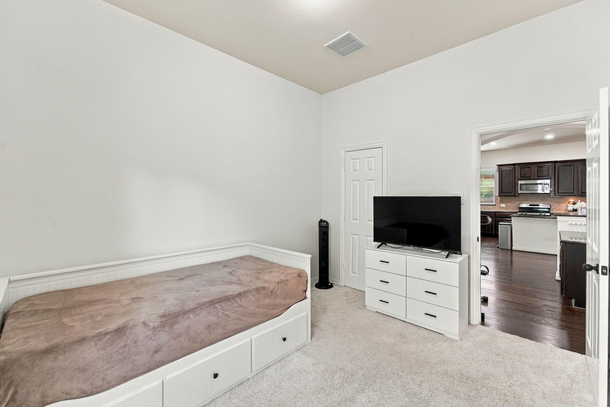 Soft carpet and a closet make this bedroom practical for everyday living, with easy access to the kitchen nearby.