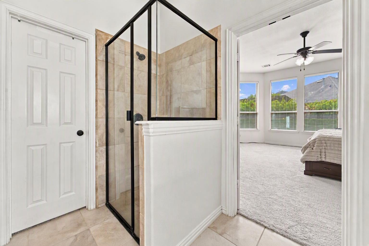 The walk-in shower of the primary bathroom, with tile surround and glass enclosure.