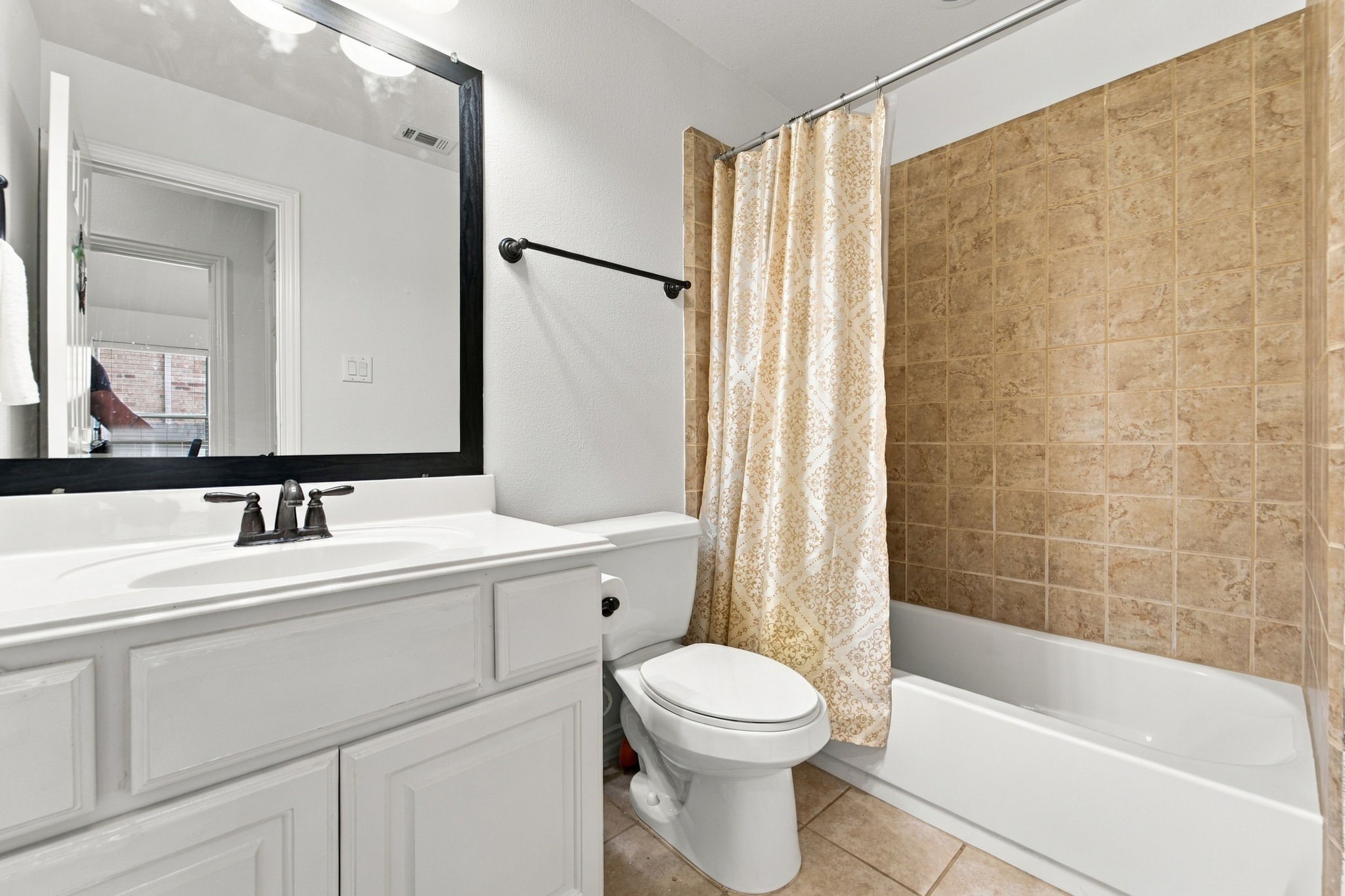 Ready for guests or family, this full bathroom has a tub and shower combination and a single-sink vanity.