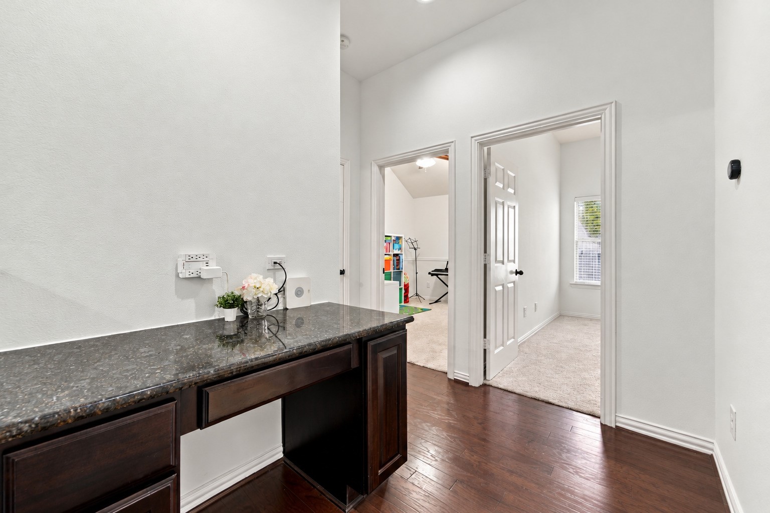 Charming built-in nook featuring granite countertops, rich cabinetry, and convenient storage. This versatile space is perfect for a coffee station, homework area, or everyday organization.
