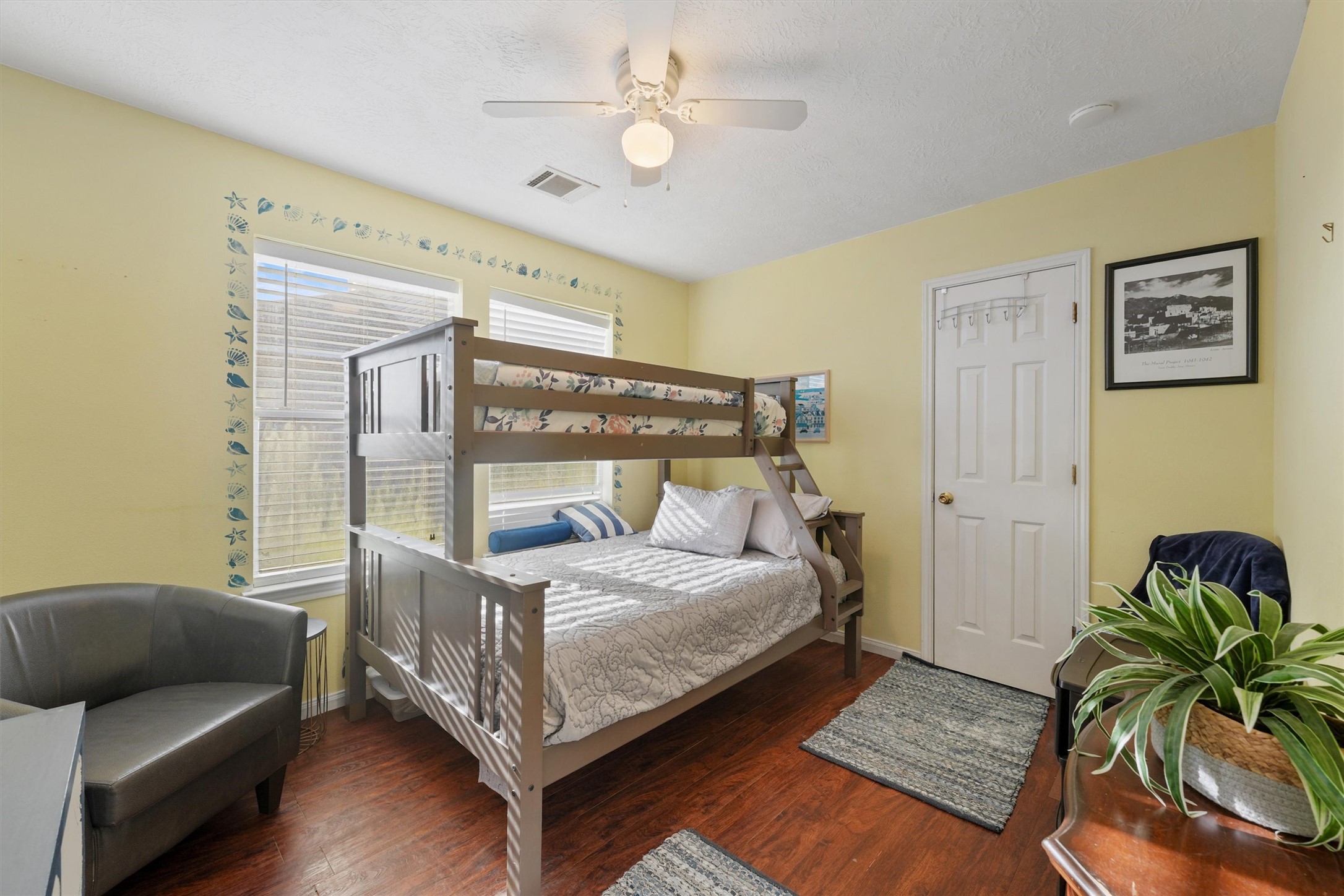 Secondary bedroom features large windows, custom paint, and beautiful floors.