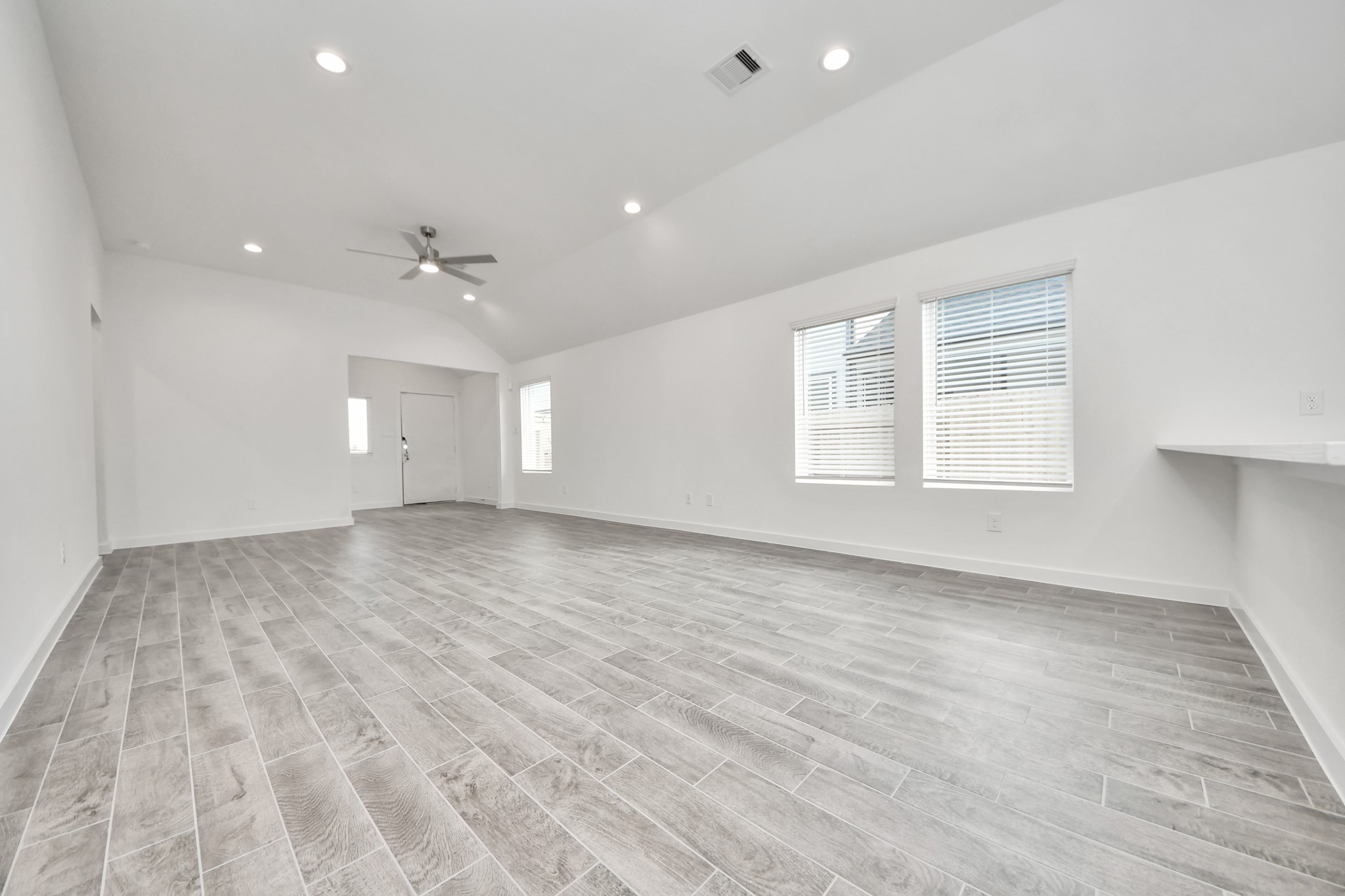 Gather the family and guests together in your lovely living room! Featuring soaring high ceilings, recessed lighting, ceiling fan, custom paint, gorgeous floors, and large windows that provide plenty of natural lighting throughout the day. Sample photo of completed home with similar floor plan. Actual colors and selections may vary.