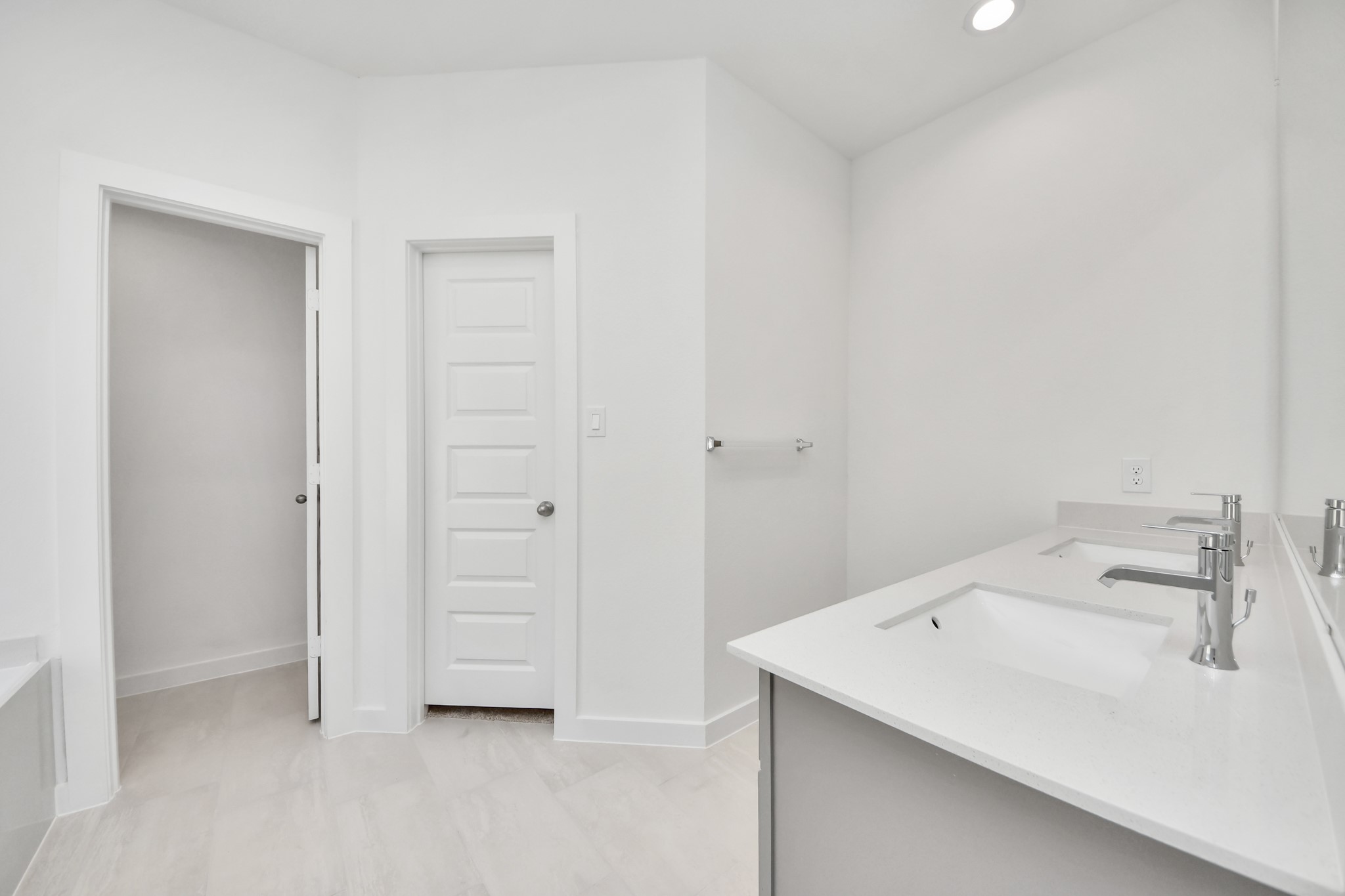Escape to a spa-like oasis in this primary bathroom. Enjoy a walk-in shower with tile surround, a separate garden tub with custom detailing, and an elegant vanity featuring light countertops, modern hardware, and beautiful recessed lights. Experience luxury and relaxation in every detail. Sample photo of completed home with similar floor plan. Actual colors and selections may vary.