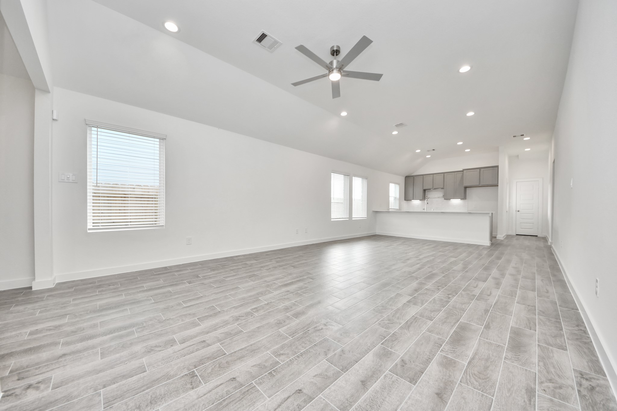 Welcome family and guests to your charming living room! With its high ceilings, recessed lighting, ceiling fan, custom paint, beautiful flooring, and large windows that let in abundant natural light, this room is perfect for gatherings. Sample photo of completed home with similar floor plan. Actual colors and selections may vary.