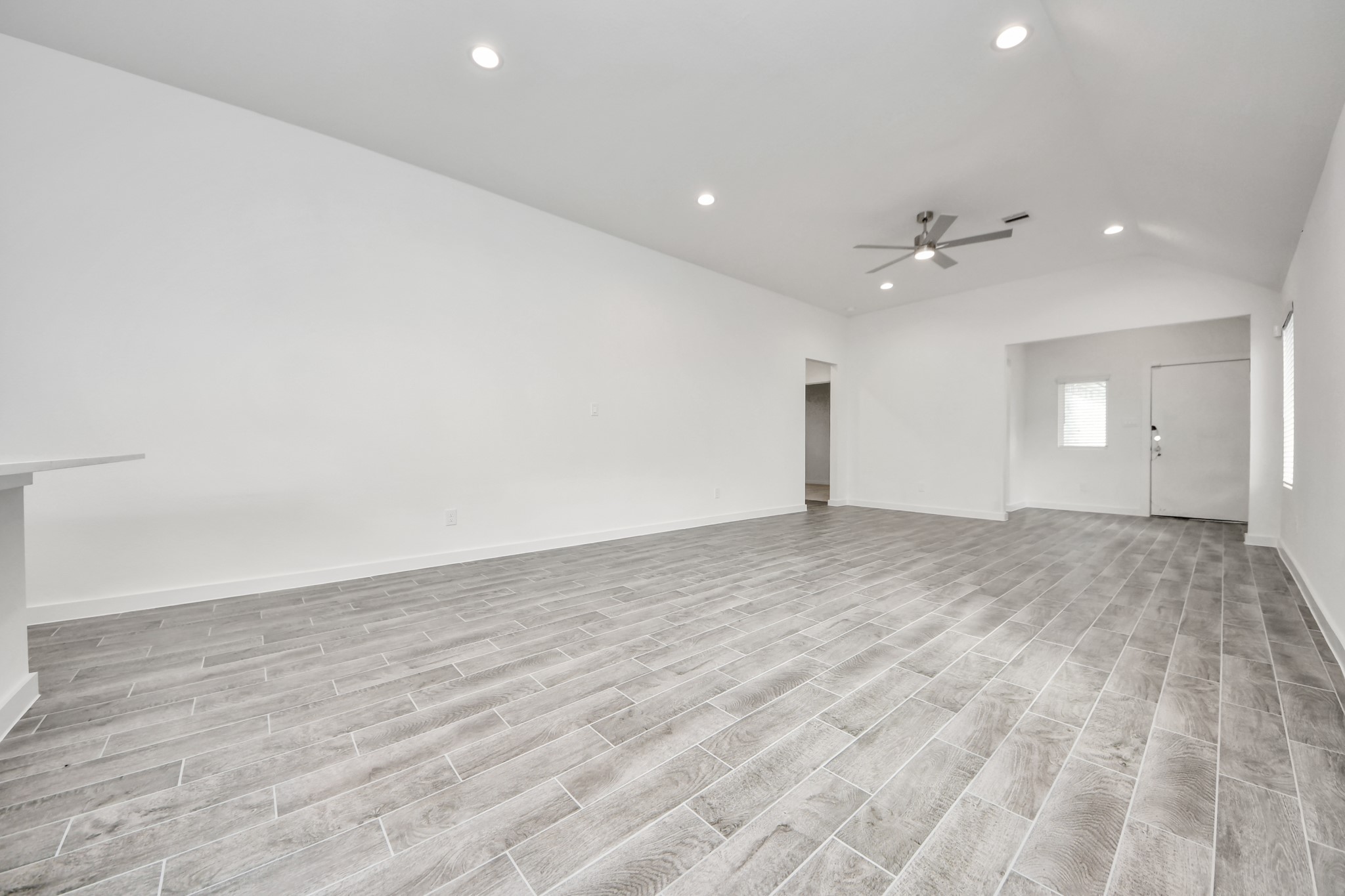 Family room flooded with natural light through the expansive windows.  The premium tile flooring adds a touch of luxury to the space, creating the perfect setting for relaxing moments and cherished gatherings with loved ones. Sample photo of completed home with similar floor plan. Actual colors and selections may vary.