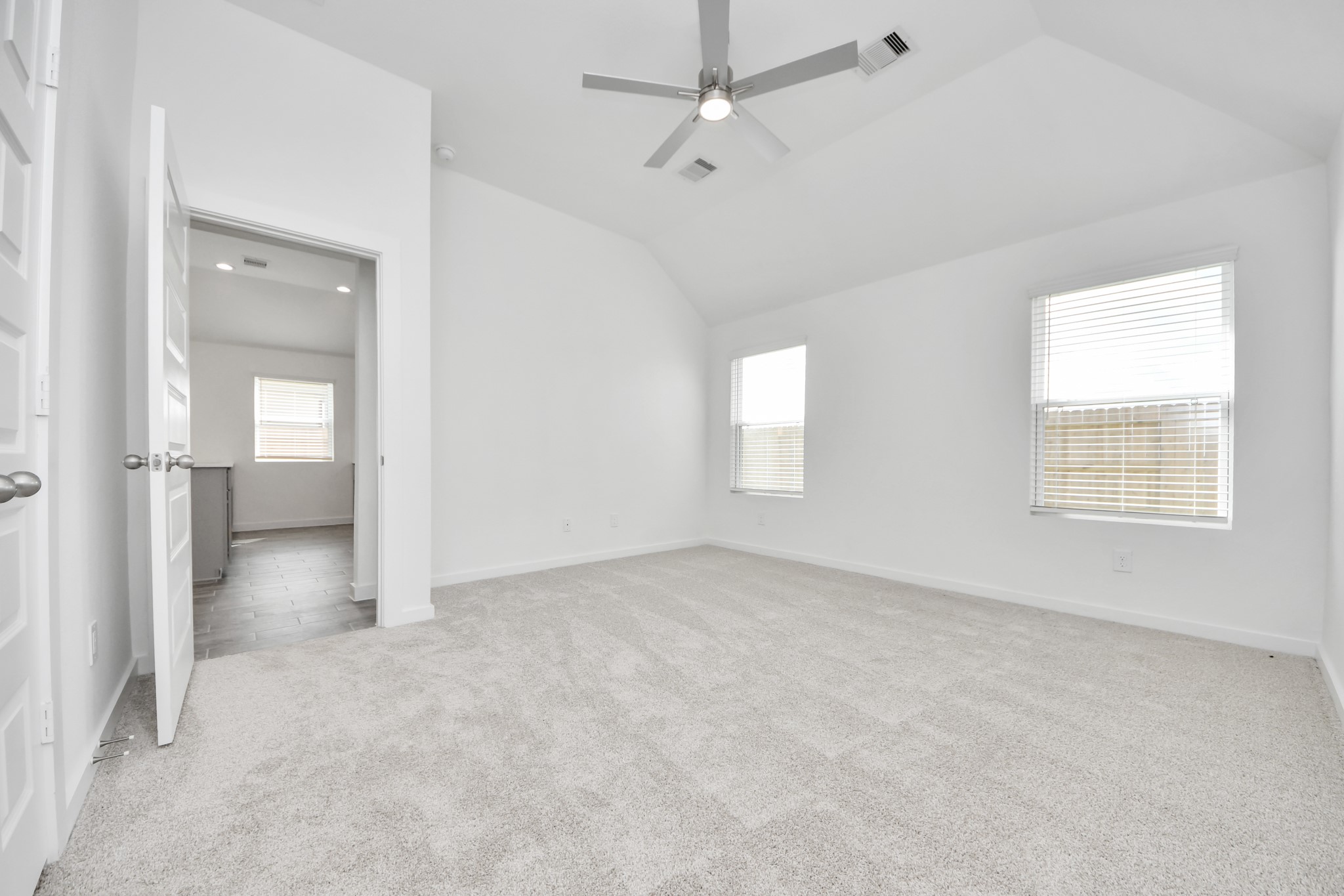 Come and unwind after a long day in this magnificent primary suite! This spacious room features plush carpet, warm paint, high ceilings and large windows with privacy blinds. v