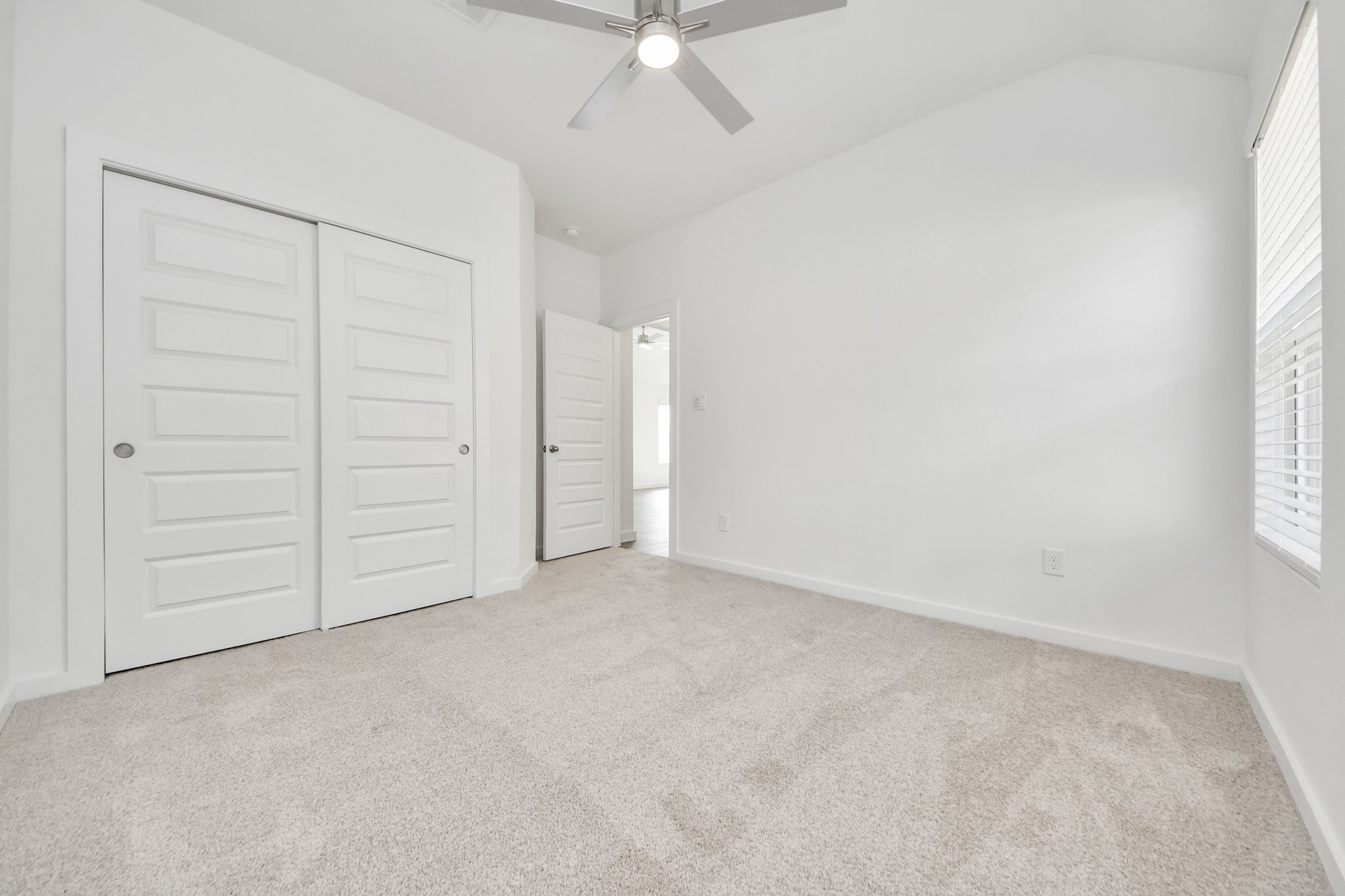 Secondary bedroom features plush carpeting, large windows that let in plenty of natural light, bright paint, and spacious closets. Sample photo of completed home with similar floor plan. Actual colors and selections may vary.