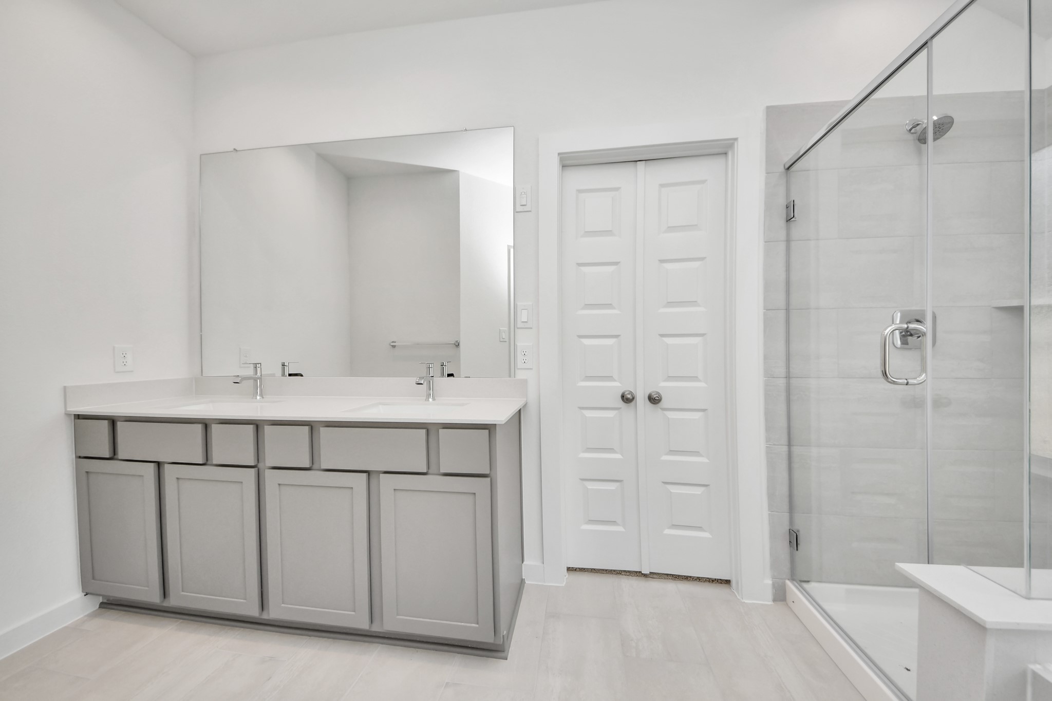 Elevate your daily routine at the elegant vanity, now equipped with double sinks, light countertops, modern hardware, and beautiful recessed lights. Sample photo of completed home with similar floor plan. Actual colors and selections may vary.
