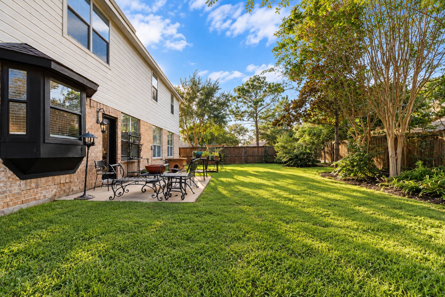 Notice the distinctive bay window and beautifully maintained backyard.