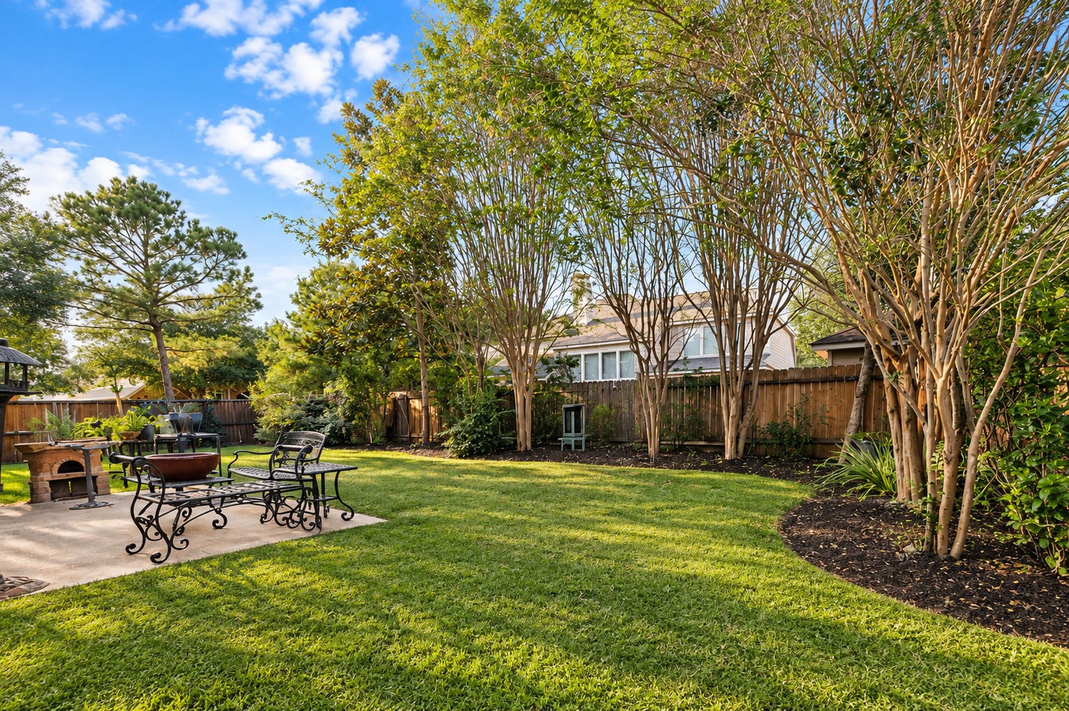 This inviting retreat offers a charming patio for outdoor dining and an expansive lawn.