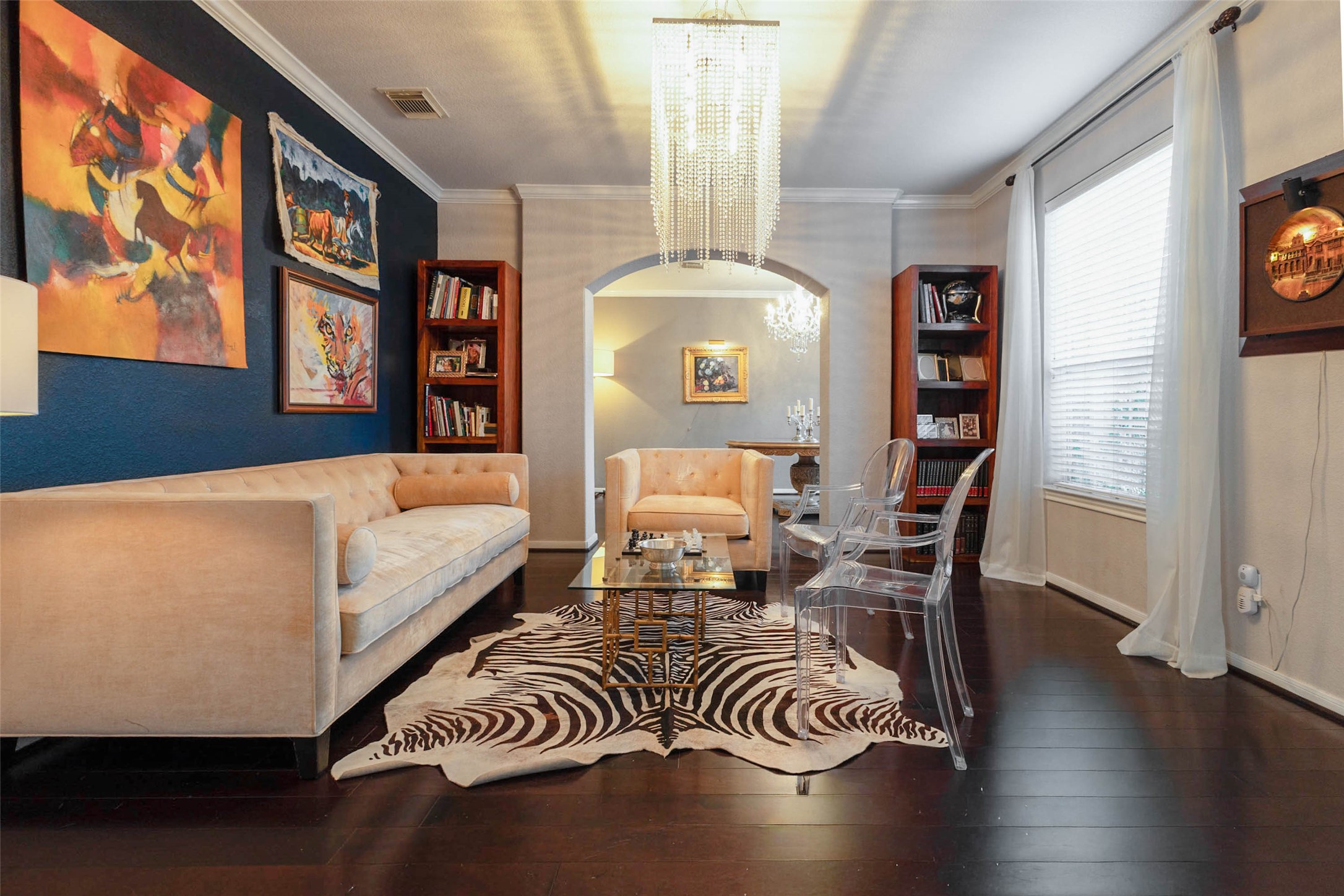 A dramatic navy accent wall, rich hardwood flooring create a sophisticated space with unmistakable personality.