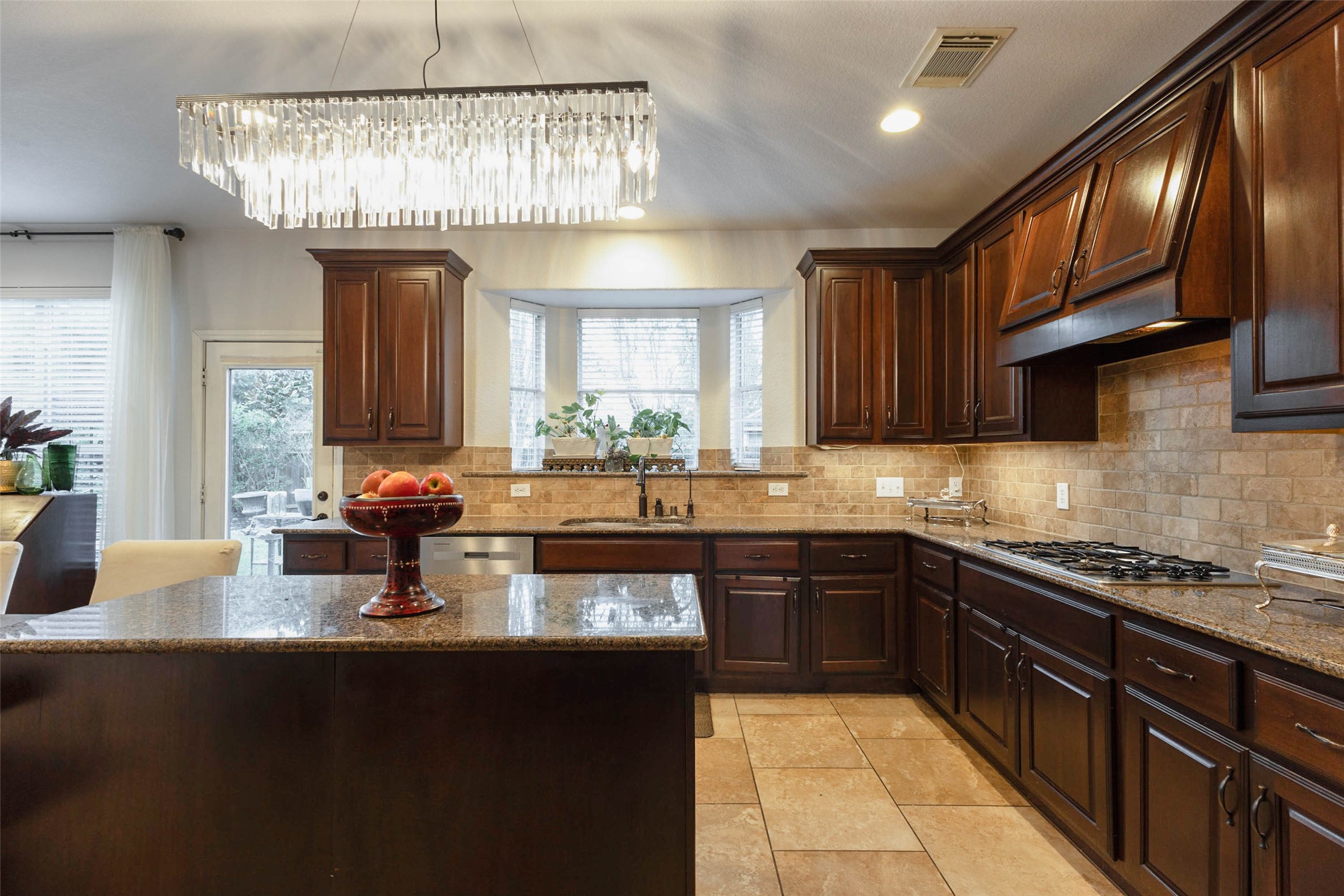 Granite countertops & richly stained cabinetry bring an elevated aesthetic to this well-appointed kitchen.