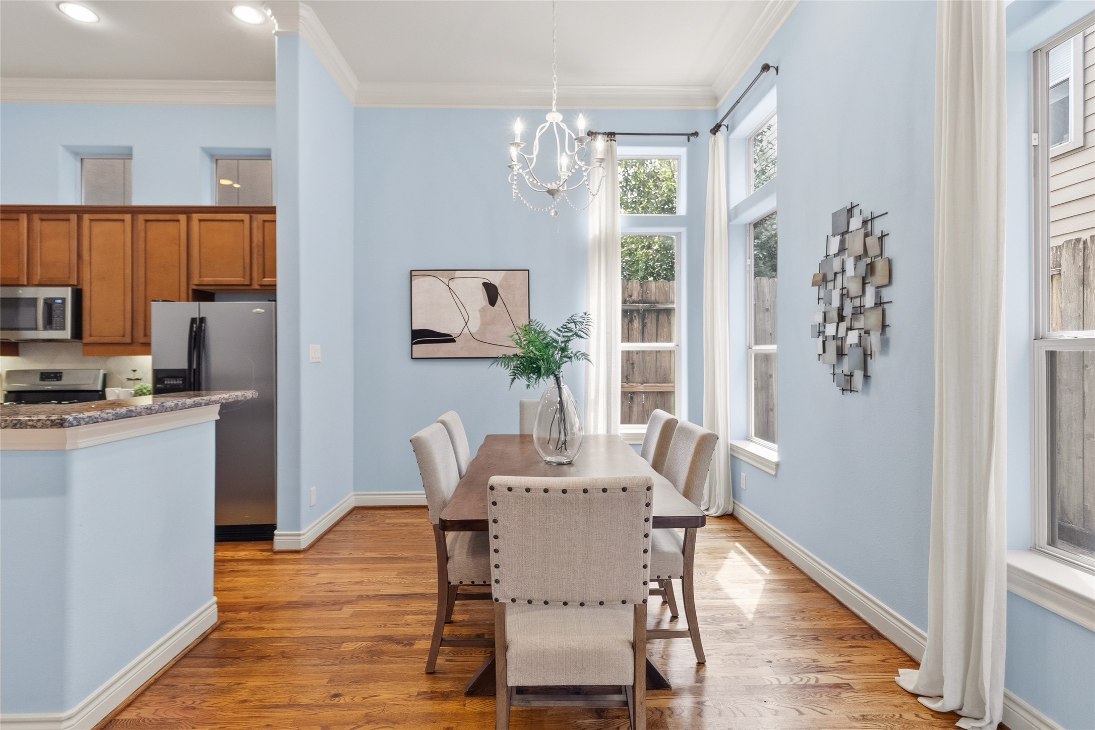 You gather around the table here, surrounded by natural light and soft finishes that make every meal feel a little more intentional. Its the kind of space that works just as well for weeknights as it does for hosting.