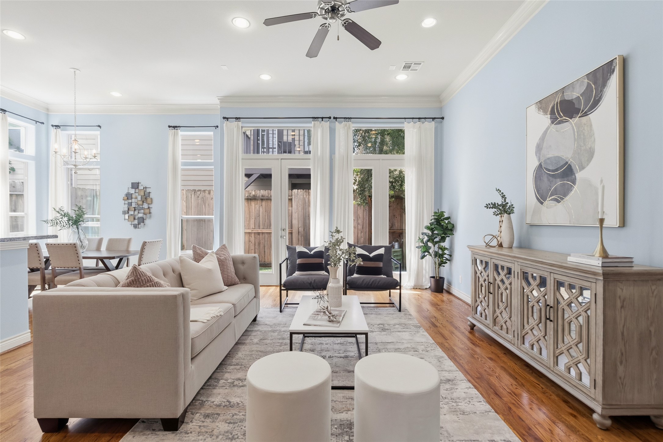 You settle into your living room where the layout naturally centers around conversation and comfort, with tall windows and doors bringing in that soft, everyday light. Its the space youll keep coming back to. Wall paint color has been virtually altered.