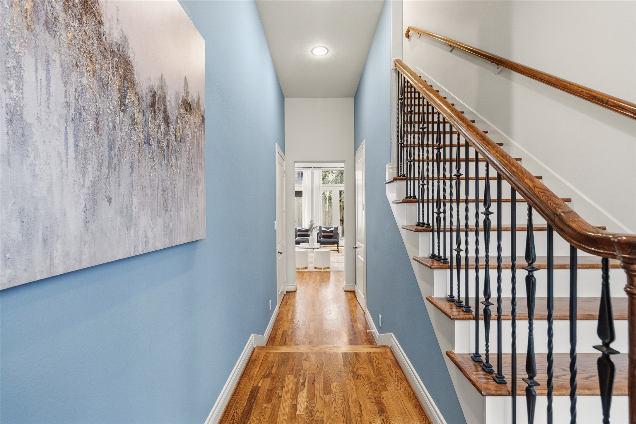 You walk in and the warm wood floors guide you straight through, with the staircase adding just the right architectural detail along the way. Natural light pulls you forward, giving you that instant this feels right moment.