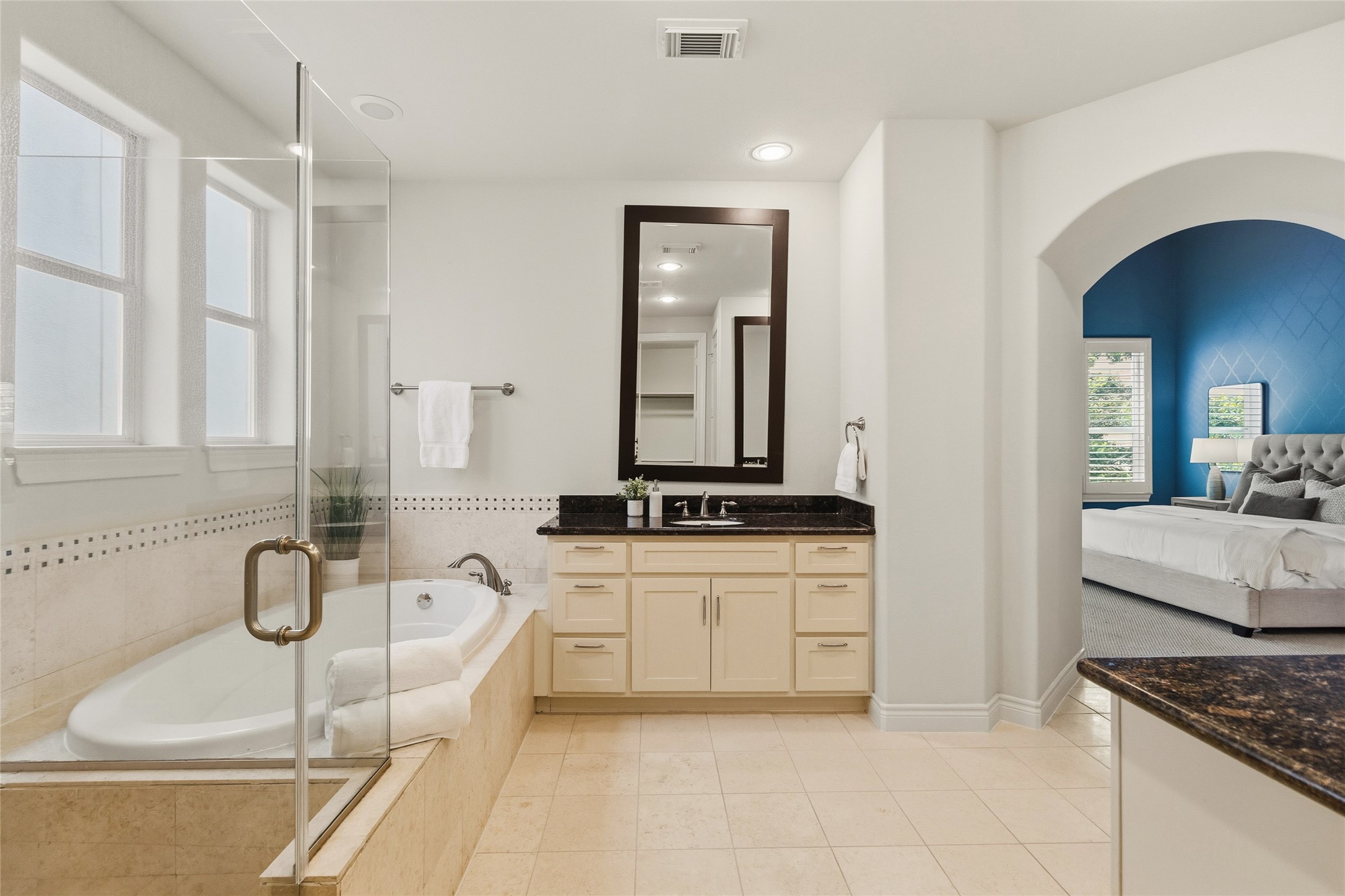 You move through a bathroom that feels open and polished, with a long vanity giving you all the space you need to get ready without rushing. The soaking tub sits right beside it, making it easy to slow down whenever you want.