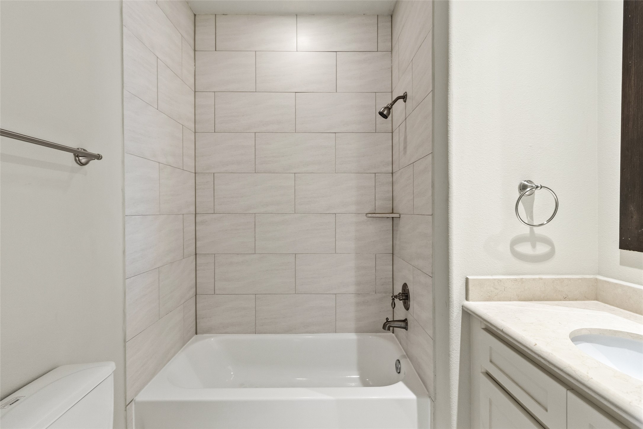 You step into a bathroom thats clean, simple, and ready for everyday use, with a full tub and tiled surround that makes it easy to unwind at the end of the day. Everything feels fresh and low-maintenance.
