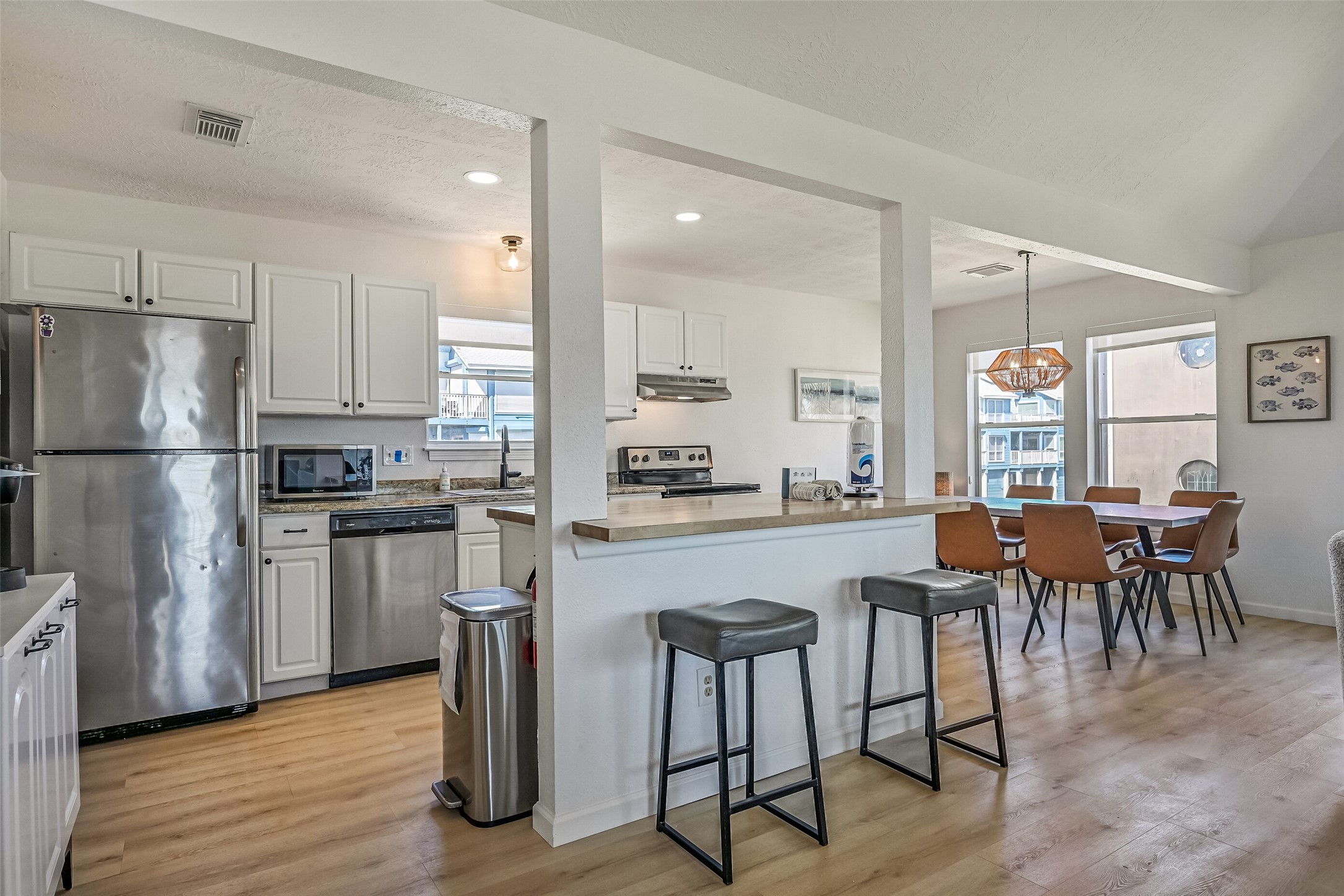 Designed with entertaining in mind, the kitchen features a spacious island with breakfast bar seating, beautiful granite and butcher block countertops, and ample cabinetry.