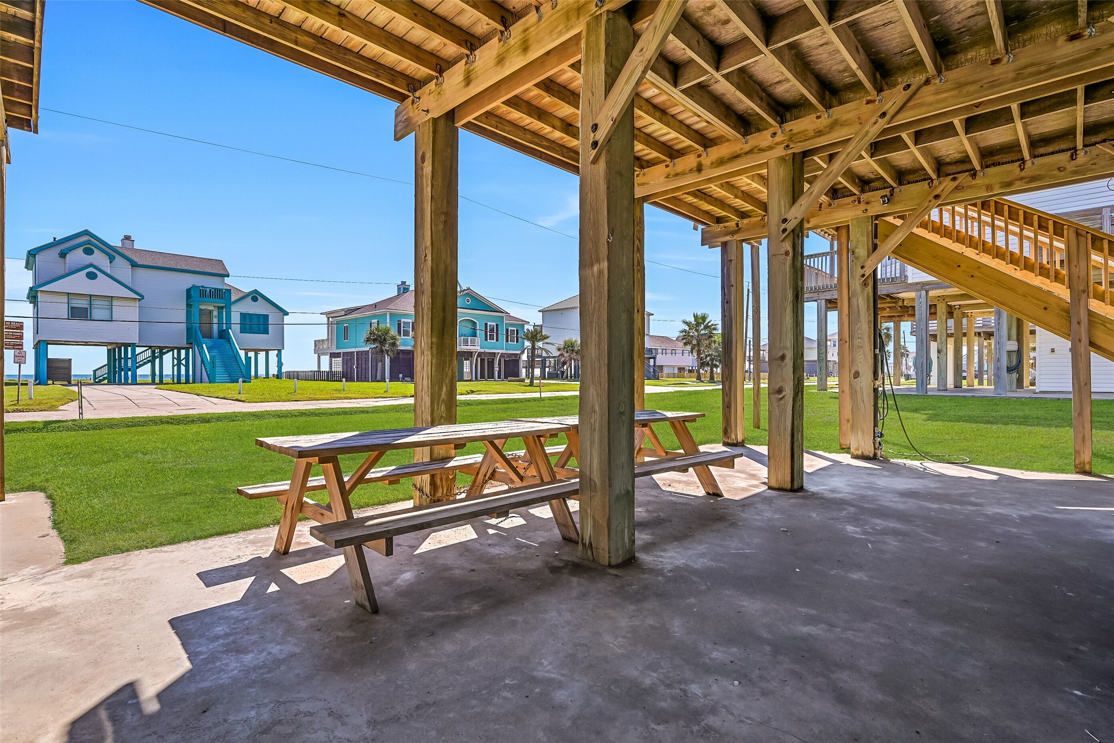 The covered ground-level area is perfect for entertaining, featuring an outdoor shower, picnic area, and convenient storage closet for keeping all your beach essentials organized.