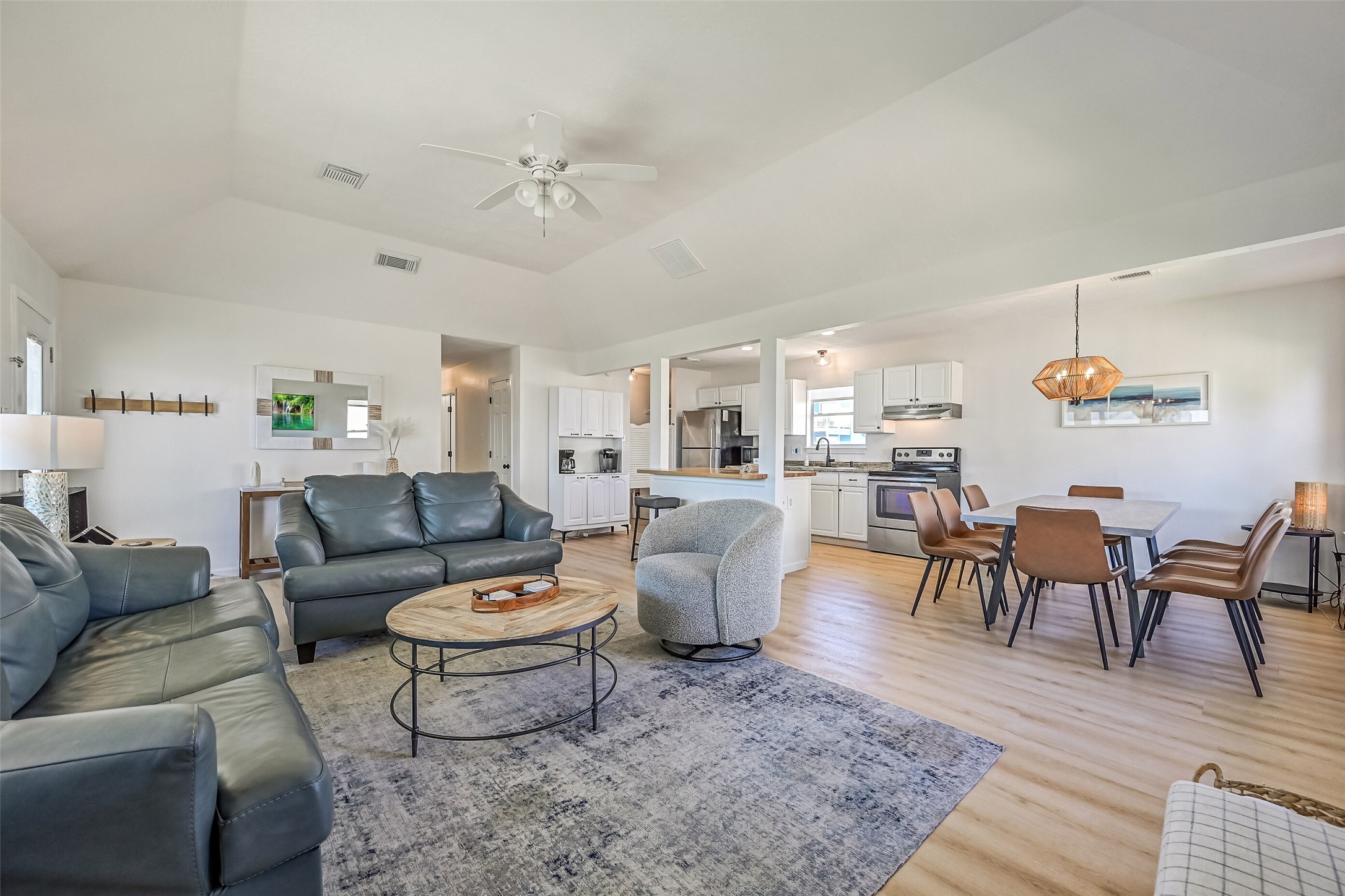 Vinyl plank flooring and soaring ceilings can be found throughout the space, creating a bright, open, and inviting atmosphere.