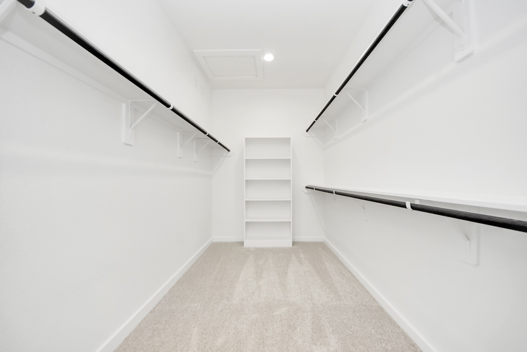Walk-in closet that epitomizes luxury and practicality. This generously sized space features built-in shelving, offering abundant room for impeccable organization. High ceilings and recessed lighting create a bright and welcoming ambiance.