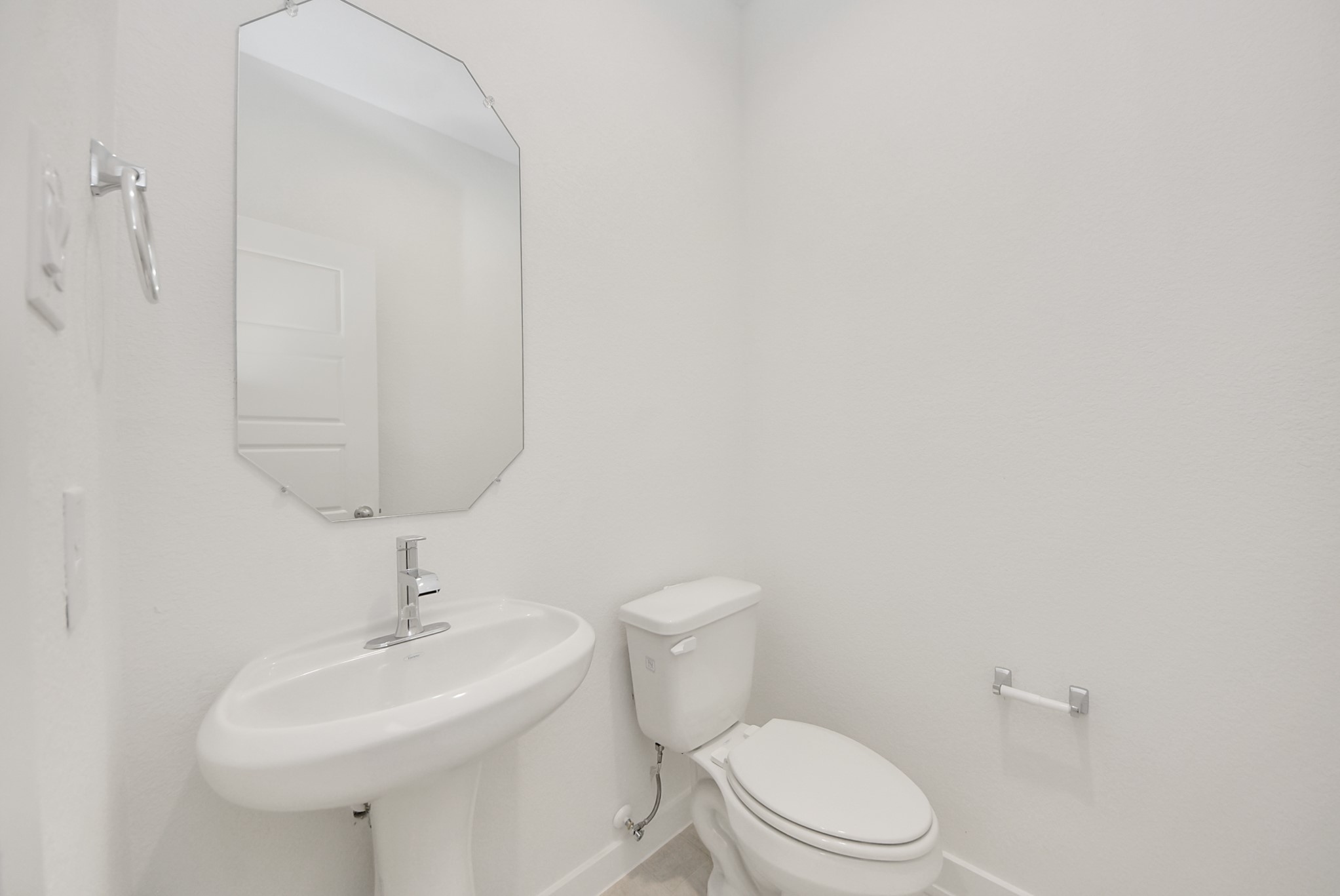 This half bathroom features a stylish pedestal sink, modern hardware, and bright recessed lighting, creating a sleek and inviting space. This half bathroom features a stylish pedestal sink, modern hardware, and bright recessed lighting, creating a sleek and inviting space.