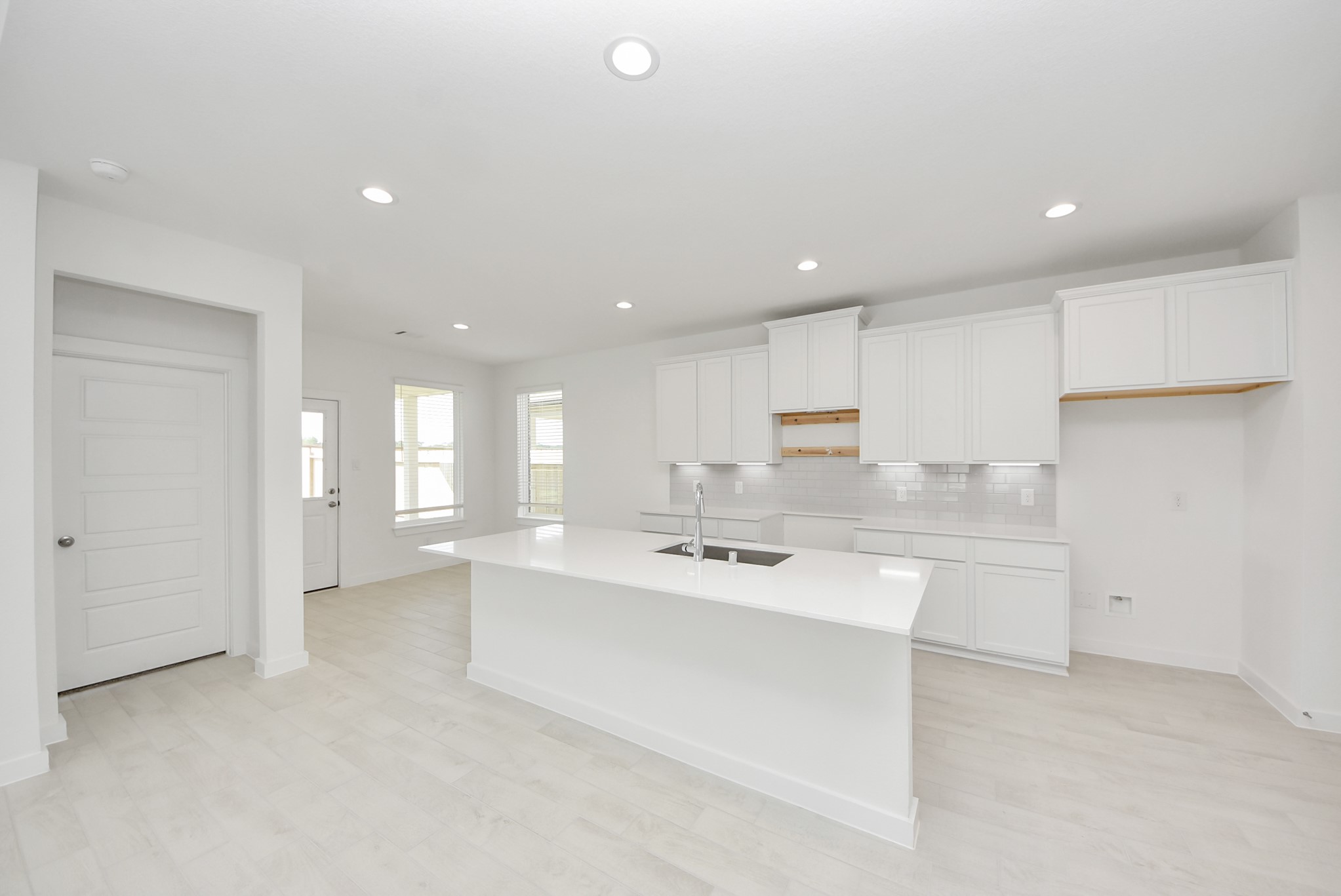This kitchen is by far any chefs dream! This spacious kitchen features high ceilings, stained wood cabinets, granite countertop, SS appliances, modern tile backsplash, recessed lighting, extended counter space, granite kitchen island with double sink, and space for breakfast bar, and a walk-in pantry all overlooking your huge family room.