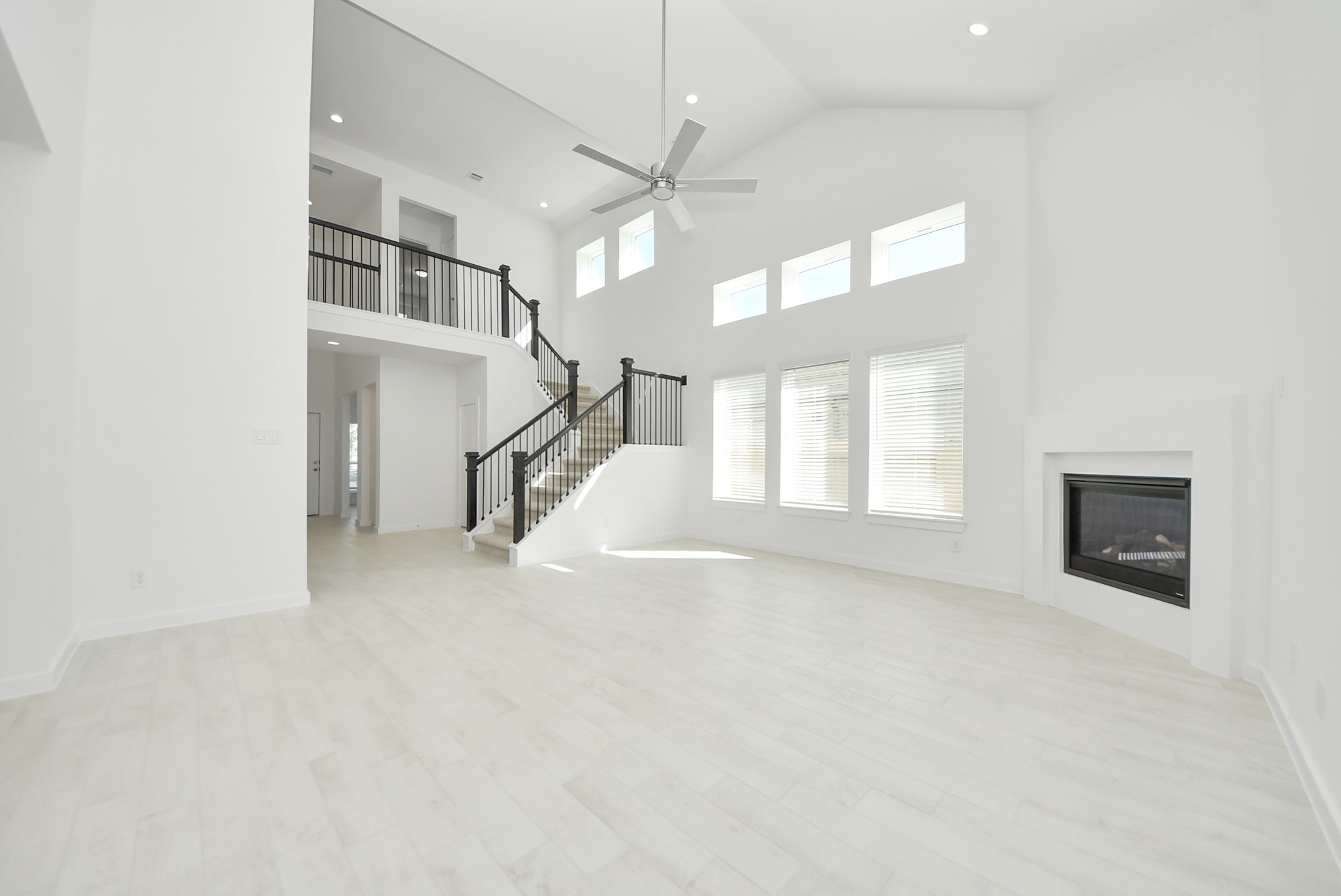 Welcome family and guests to your charming living room! With its high ceilings, recessed lighting, ceiling fan, custom paint, beautiful flooring, and large windows that let in abundant natural light, this room is perfect for gatherings.